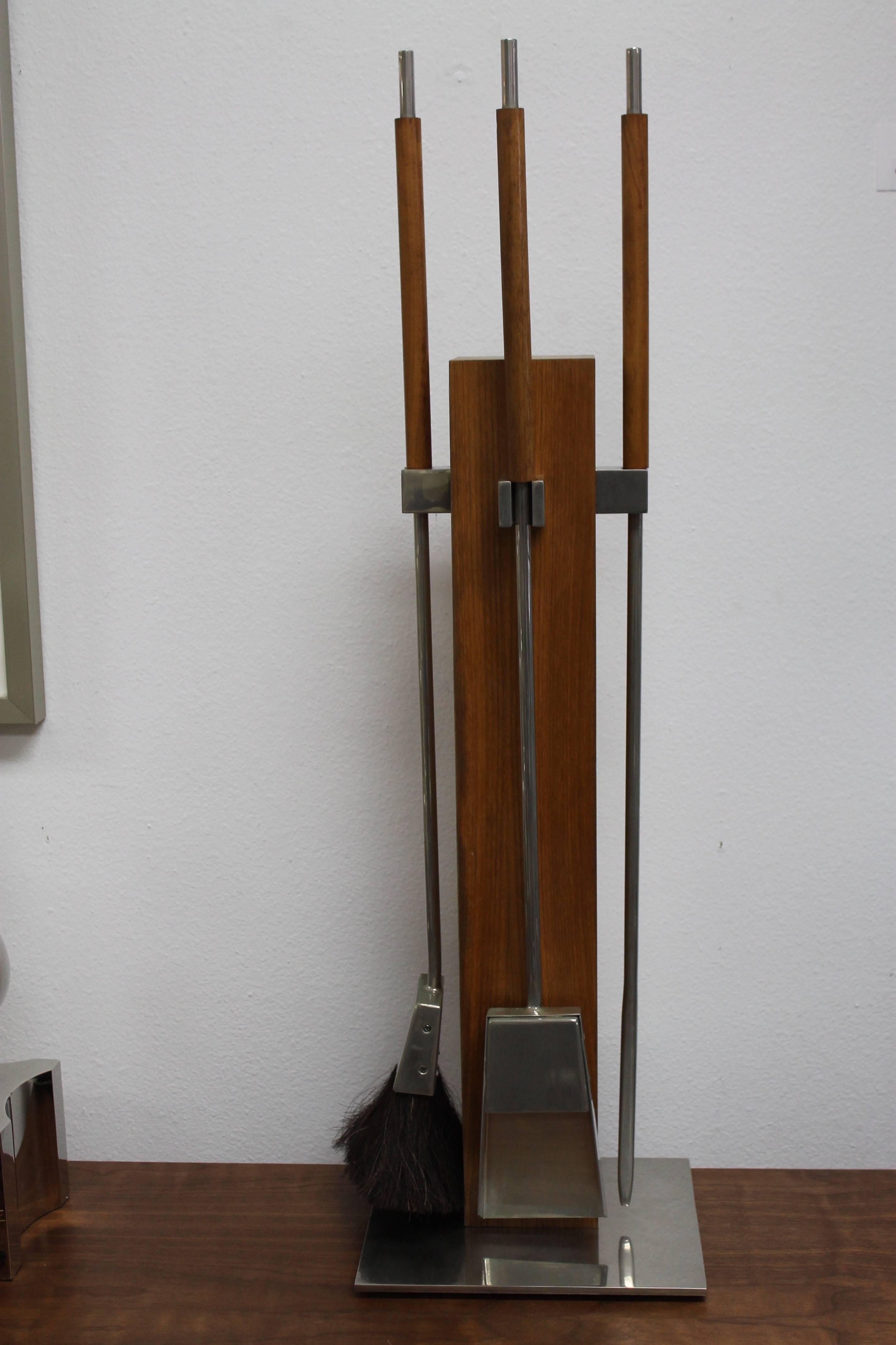 A three piece fire place tool set attributed to Allesandro Albrizzi.  Fire place set consists of steel tools and holder.  Walnut handles and veneer block.  Base is 10