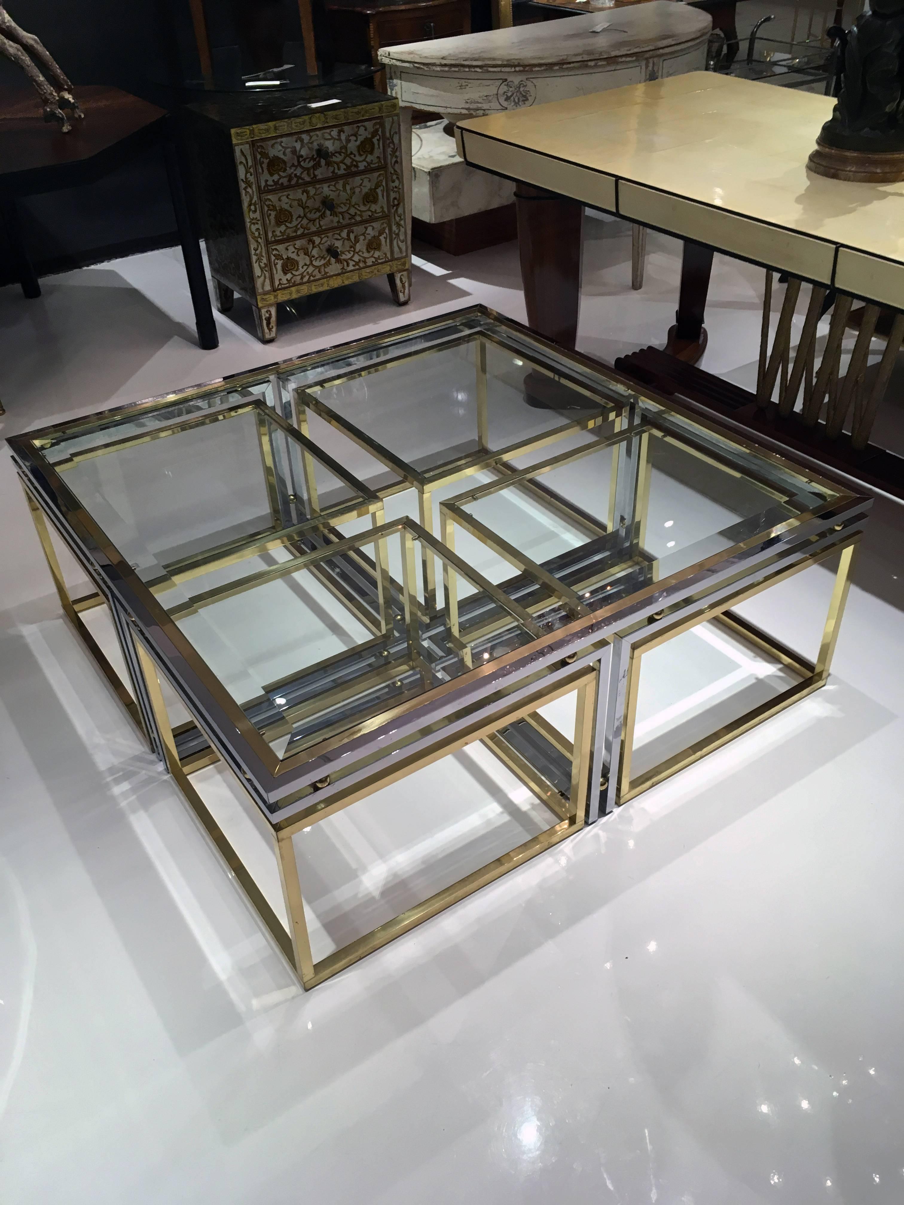This set consist of one chrome and beveled glass coffee table and four brass nesting tables. The set was made in the 1960s by Maison Charles.