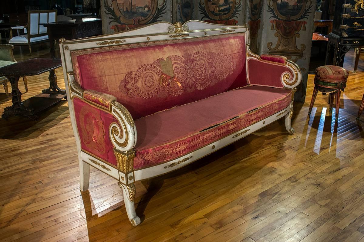 Pair of French painted and gilt sofas with slightly arched back, front curved legs. Beautiful detail scroll arms and visible back.