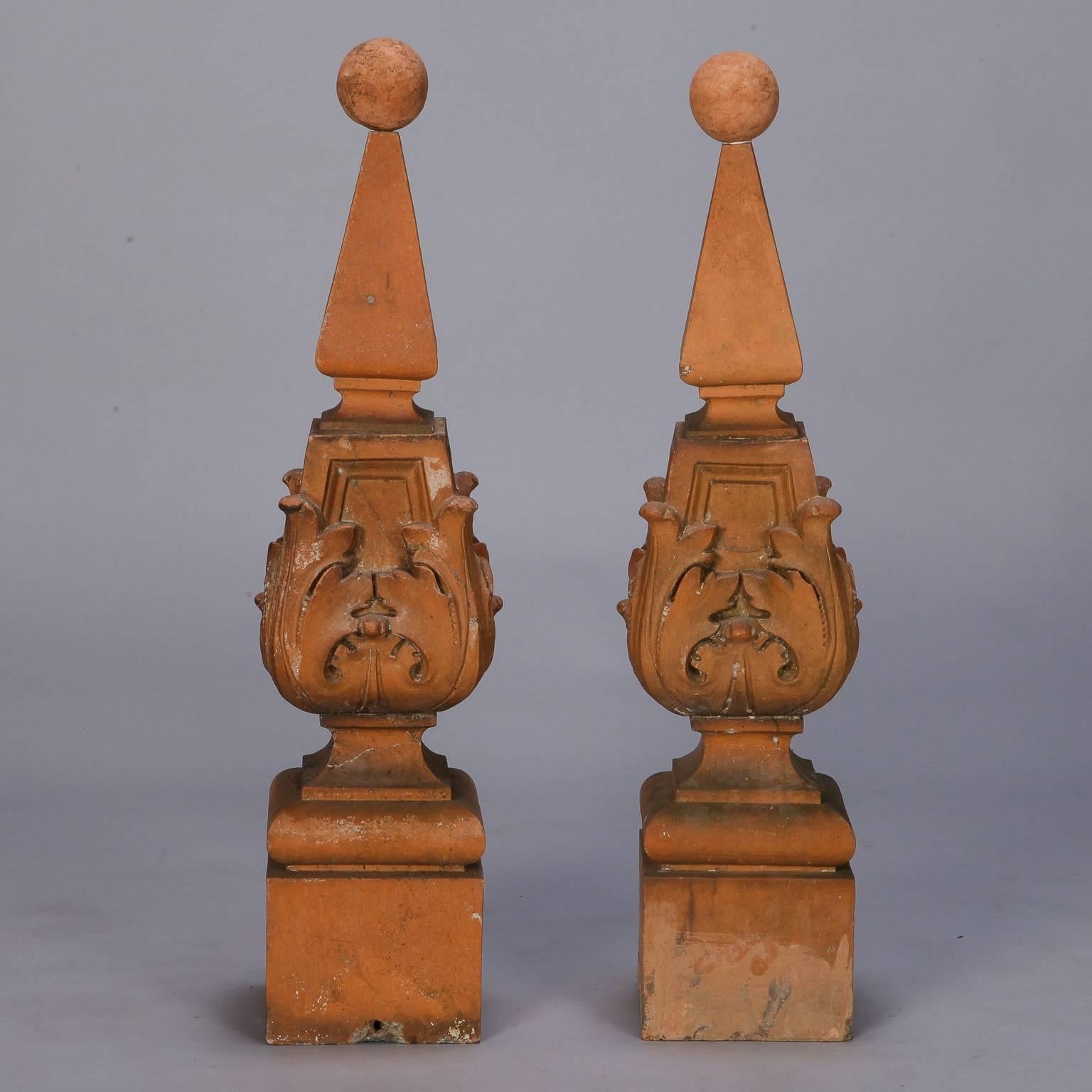 Found in England, these circa 1900 terra cotta finials are priced and sold separately. Square base supports vessel form center with foliate details and pyramid shapes topped with terra cotta spheres. Surfaces show age and patina. 