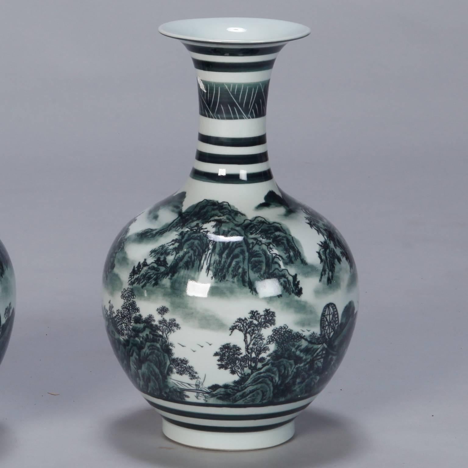 Pair of Chinese porcelain vases with round bodies and flared necks with decorative glaze that depicts traditional mountain-scape scenery in shades of deep green and white. Sold and priced as a pair.