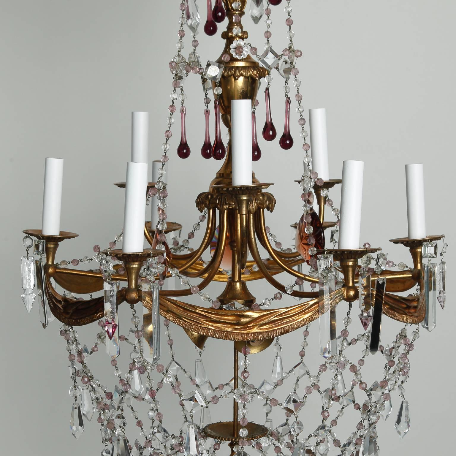 French chandelier with brass frame, tole details and two tiers of candle arms, circa 1900 There are a total of 12 sockets with three candle arms on the top tier, six on the lower level and three down lights. Crystal draped beading and several large