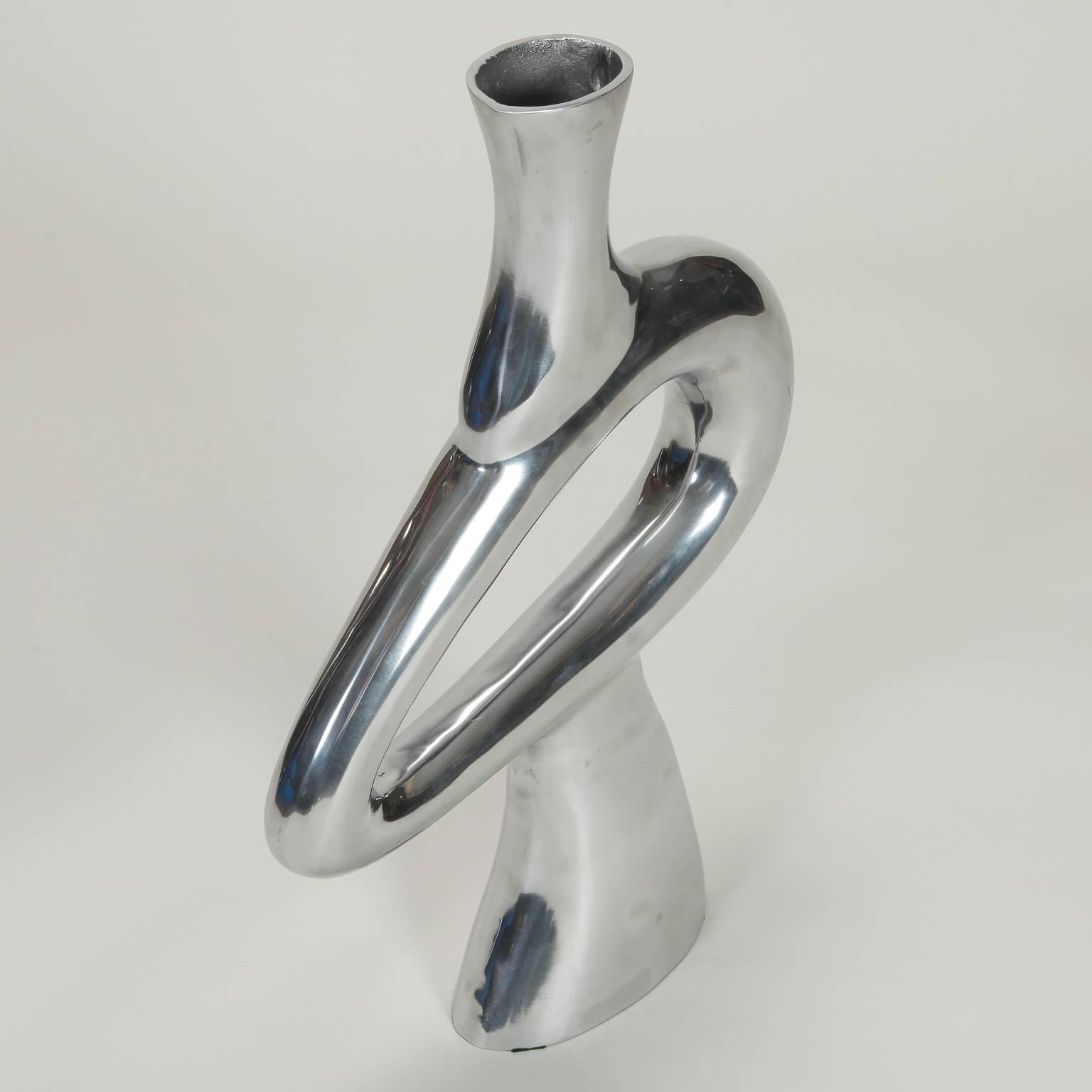 Sculptural metal vase stands two feet tall and has a center free form open loop and polished steel finish, circa 1970s.
     