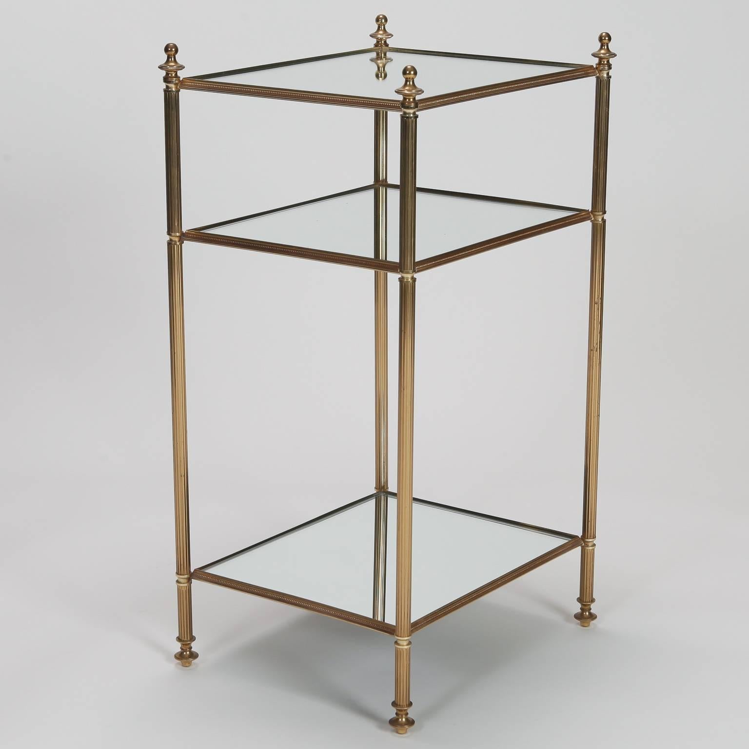 French side table with brass frame, reeded legs, decorative finials and three mirrored glass shelves, circa 1940s.
 