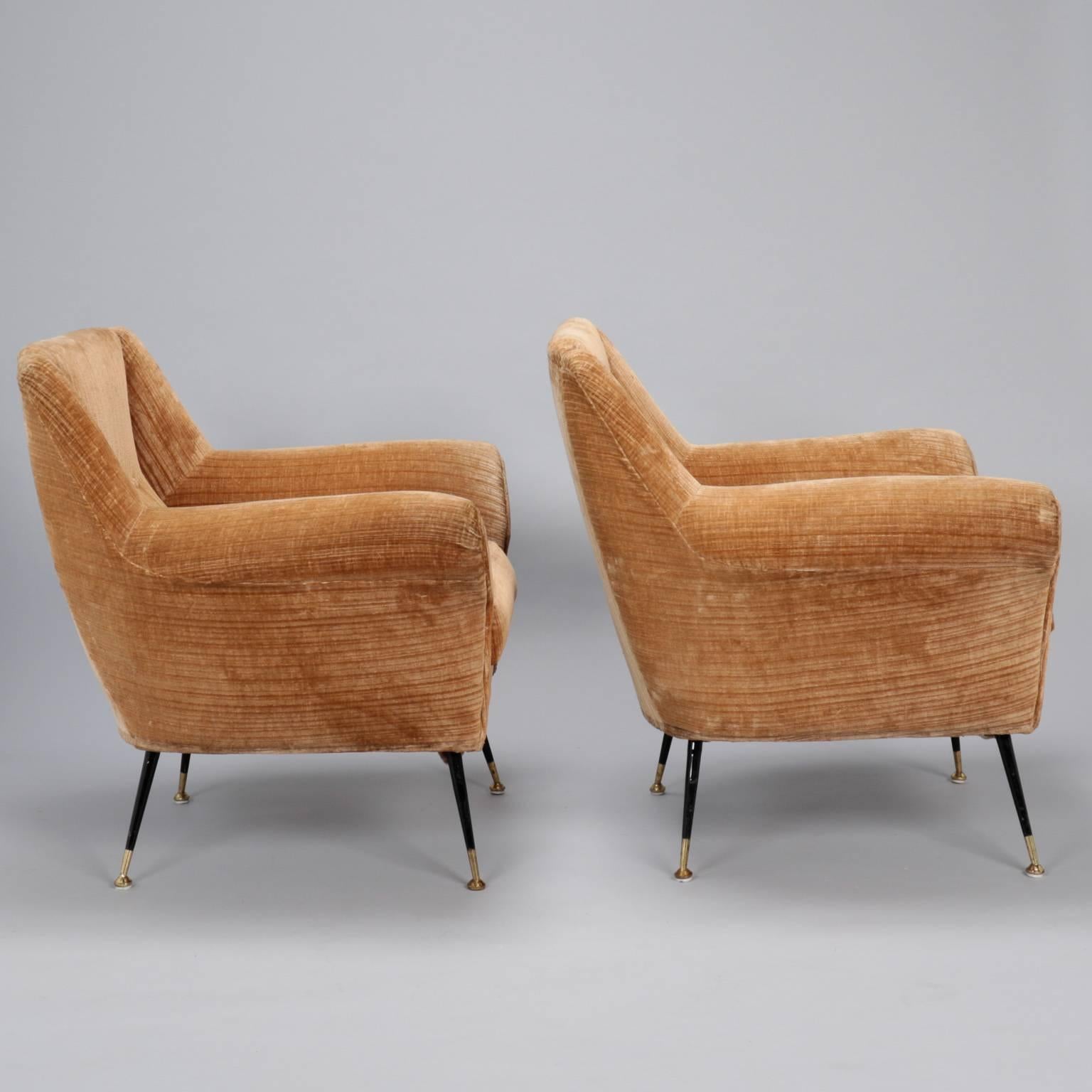 Italian armchairs with tan velvet upholstery, circa 1950s attributed to Gigi Radice for Minotti. Curvy lines, single line of button tufting on seat backs, thin black iron legs with brass caps. Two available at time of posting - Sold and priced as a