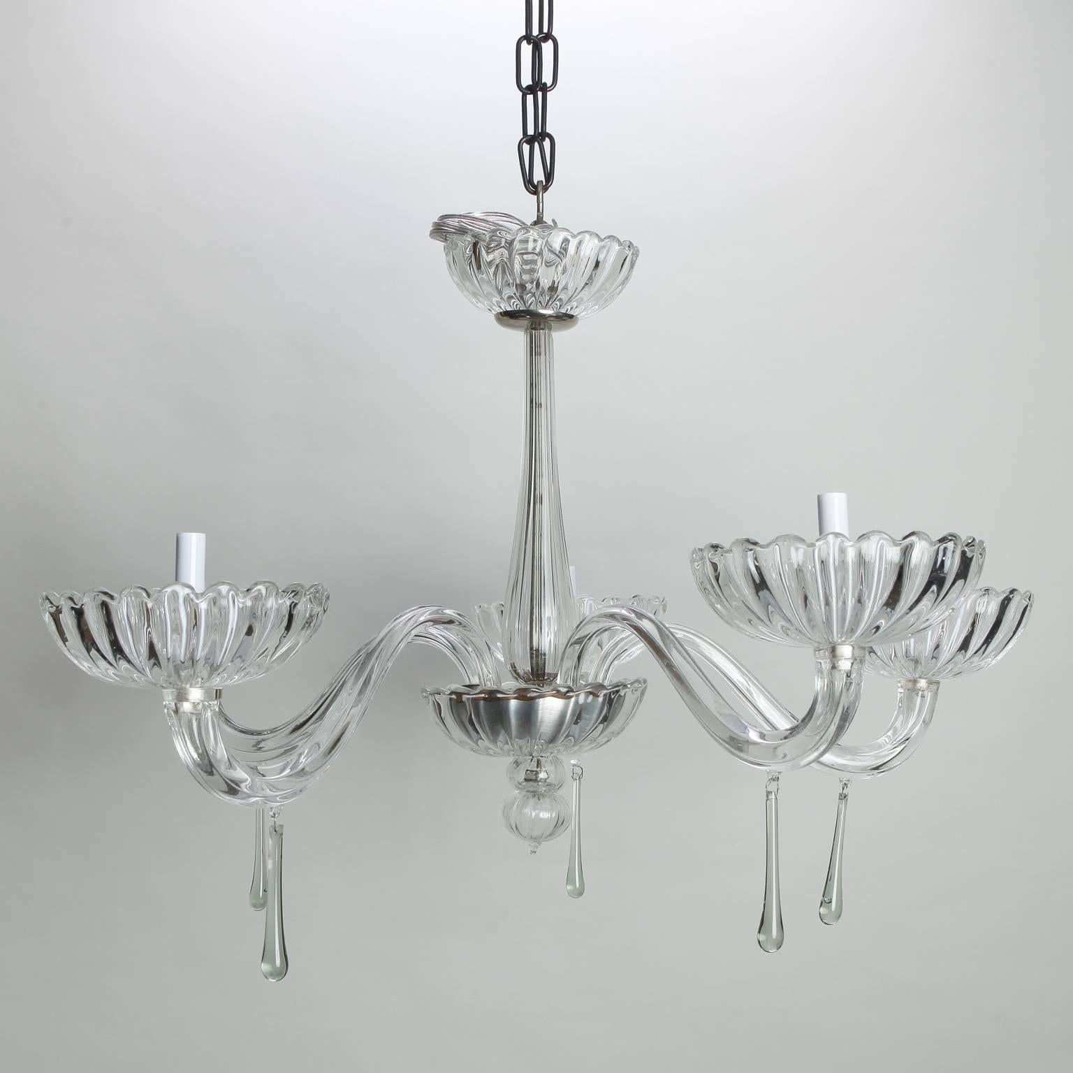 Clear Murano glass chandelier has elegant lines with five arms and ribbed bobeches, circa 1960s, long slender drops and a clear glass ceiling canopy. Excellent vintage condition with new wiring for US electrical standards.
               