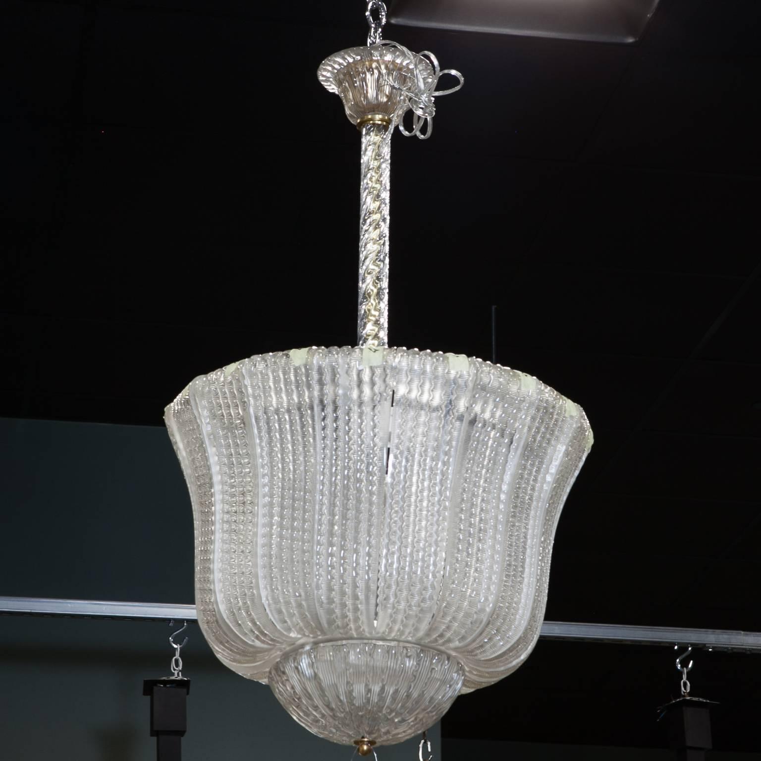 Barovier & Toso clear glass hanging fixture with curved, ribbed sides, four internal candelabra size sockets and a thick clear glass center shaft and ceiling canopy, circa 1940s. New wiring for US electrical standards. Multiple fixtures of this size