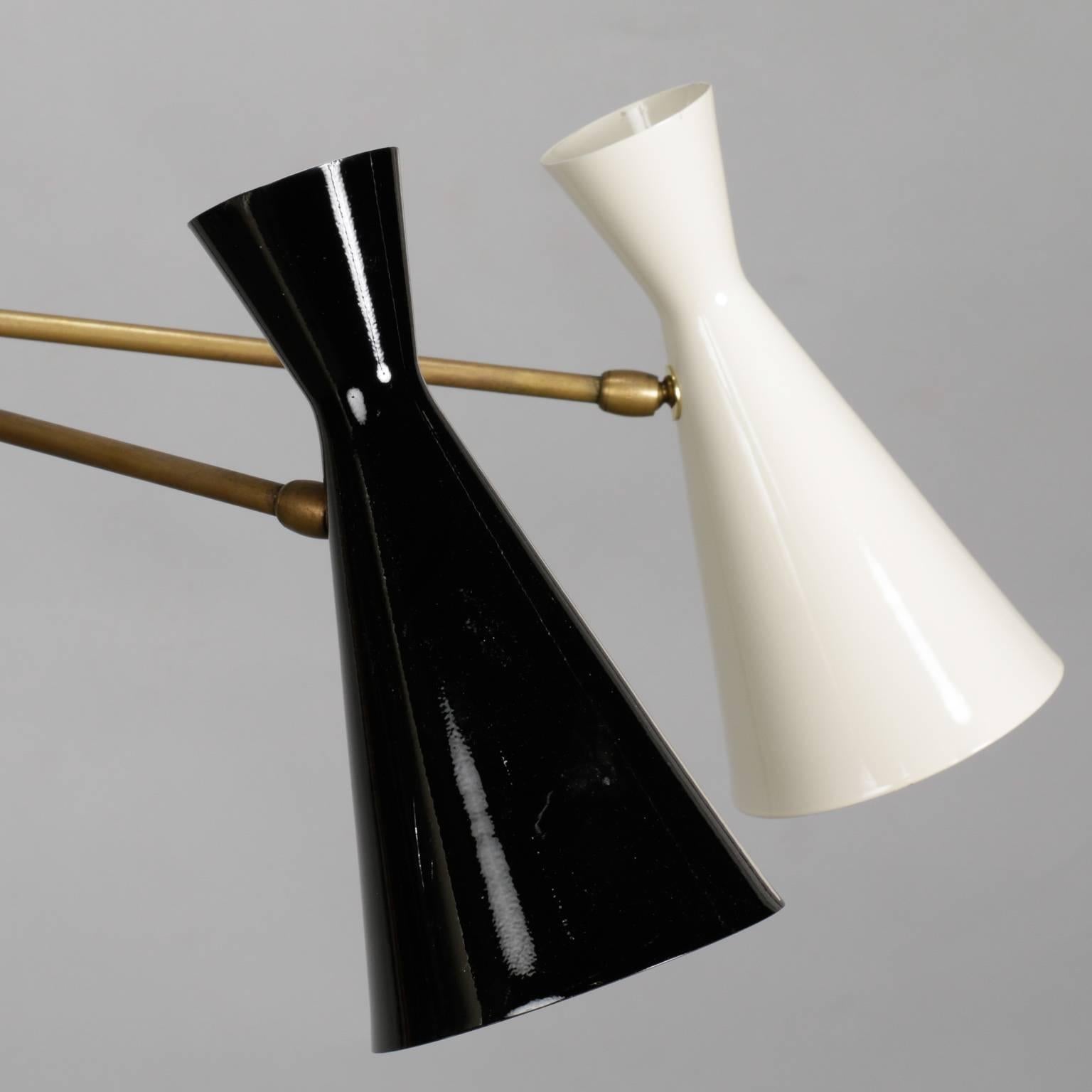 Modern black and ivory enameled metal and brass Italian hanging light fixture in style of Stilnovo, circa 1950s. Asymmetrical with three single cones on brass arm and larger double cone with one up light and one down light. Five candelabra style