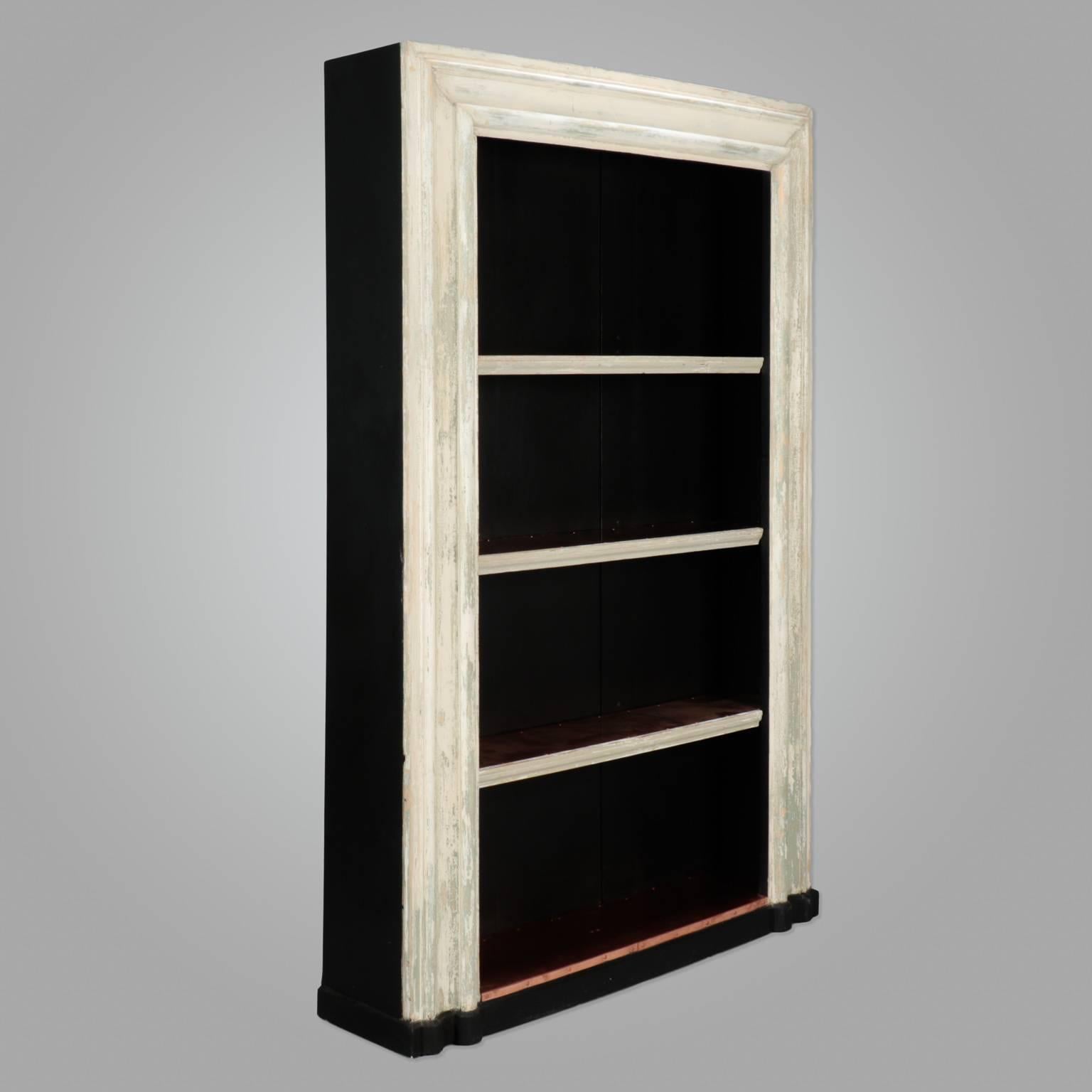 Large bookcase made from salvaged 19th century English door frame. Distressed creamy antique white painted door frame and sides now enclosed with black painted wood backing and four shelves are lined in copper sheeting.
  