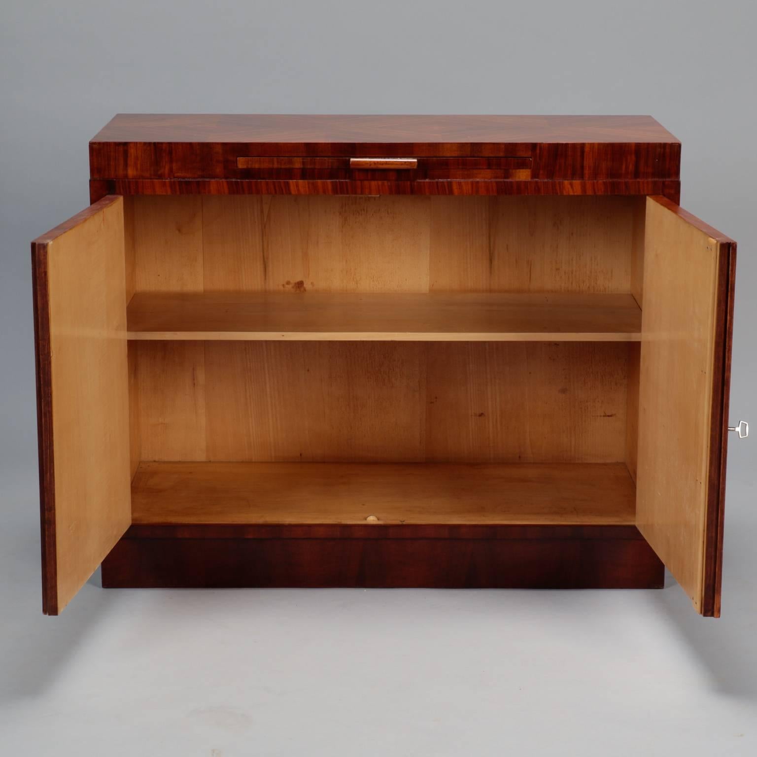 Austrian Bauhaus style/era burr wood walnut serving cabinet has a patterned veneer top with checkered pattern made with contrasting grain directions, circa 1930s. Pull-out cutting/serving tray. Two locking cabinet doors are bookmarked and open to