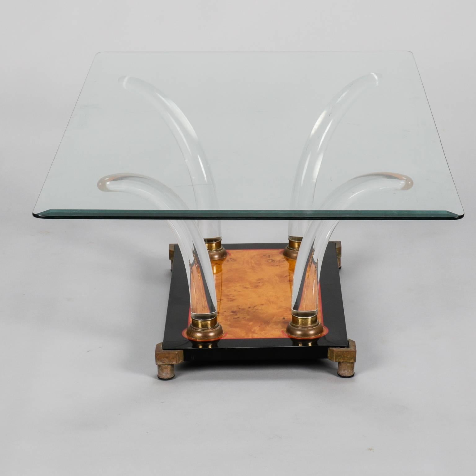 Cocktail table has a black enameled base with red accents, brass feet and burl wood center and clear Lucite tusk-shaped arms supporting a glass tabletop, circa 1970s. Found in Italy - unknown maker and origin.
  
