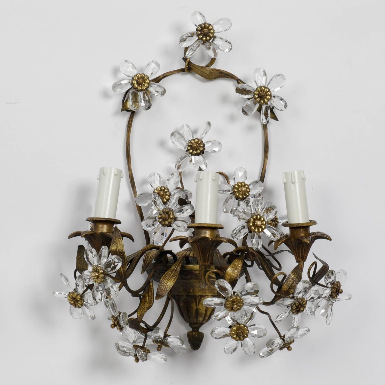 Pair of circa 1910 French wall sconces with a bronze base in the form of flower basket and three candle style lights embellished with several clear crystal and brass flowers. Sold and priced as a pair. New wiring for US electrical standards.
  