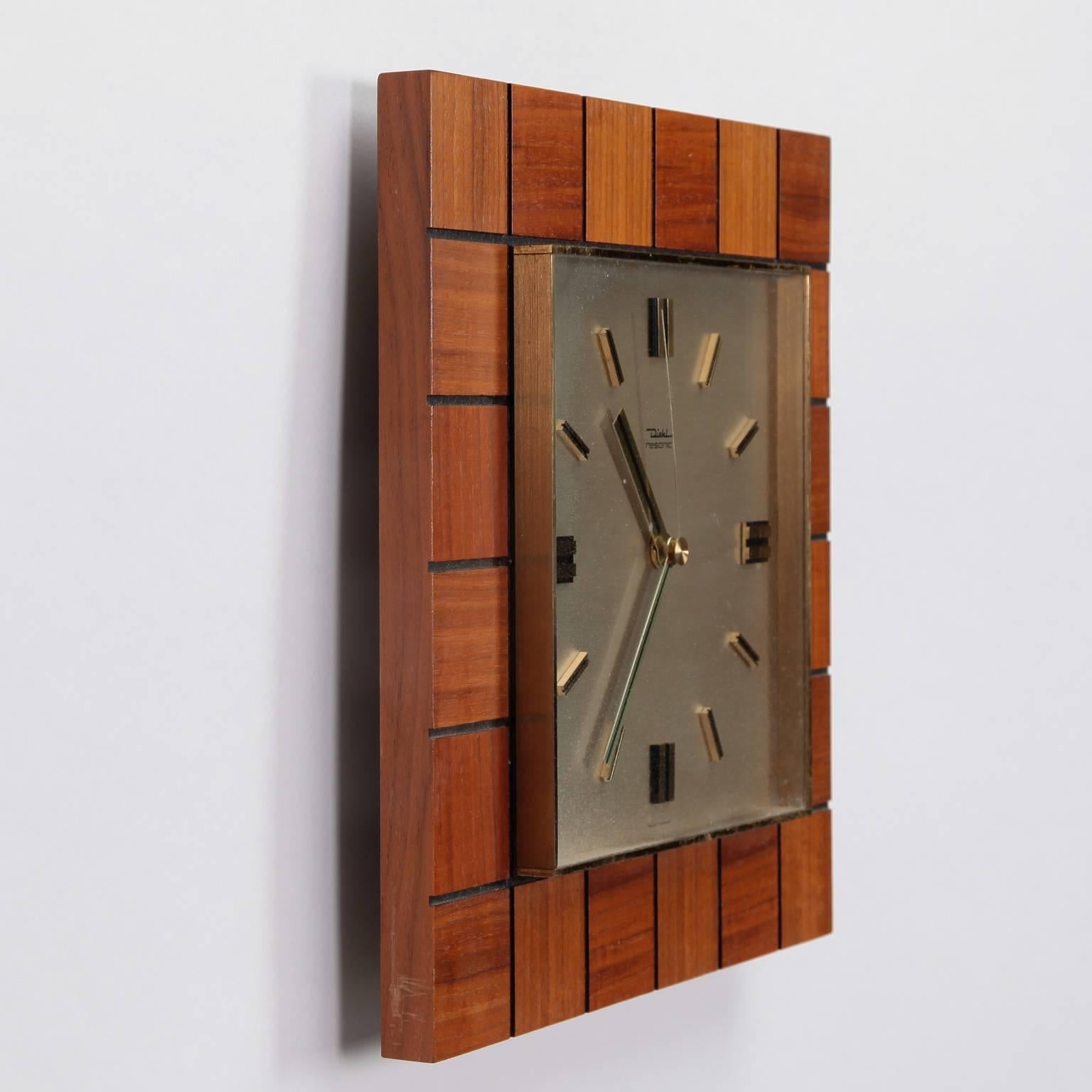 Square German battery operated wall clock by Diehl is framed with squares of teakwood surrounding the white clock face with Roman numerals, circa 1960s.