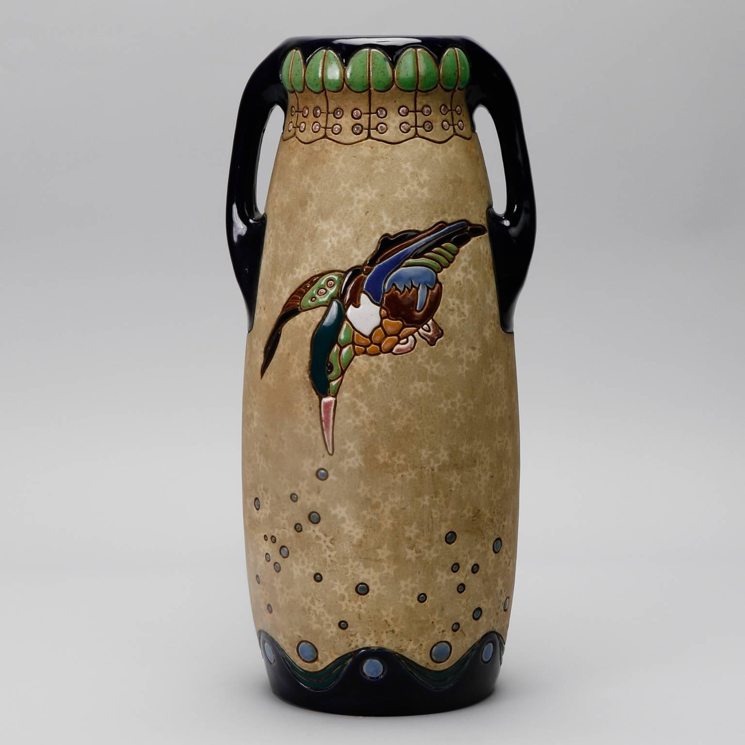 Tall vase manufactured by the Czech company Amphora (formerly of Austria) with two handles and bold, colorful birds in an enameled glaze, circa 1918.
 