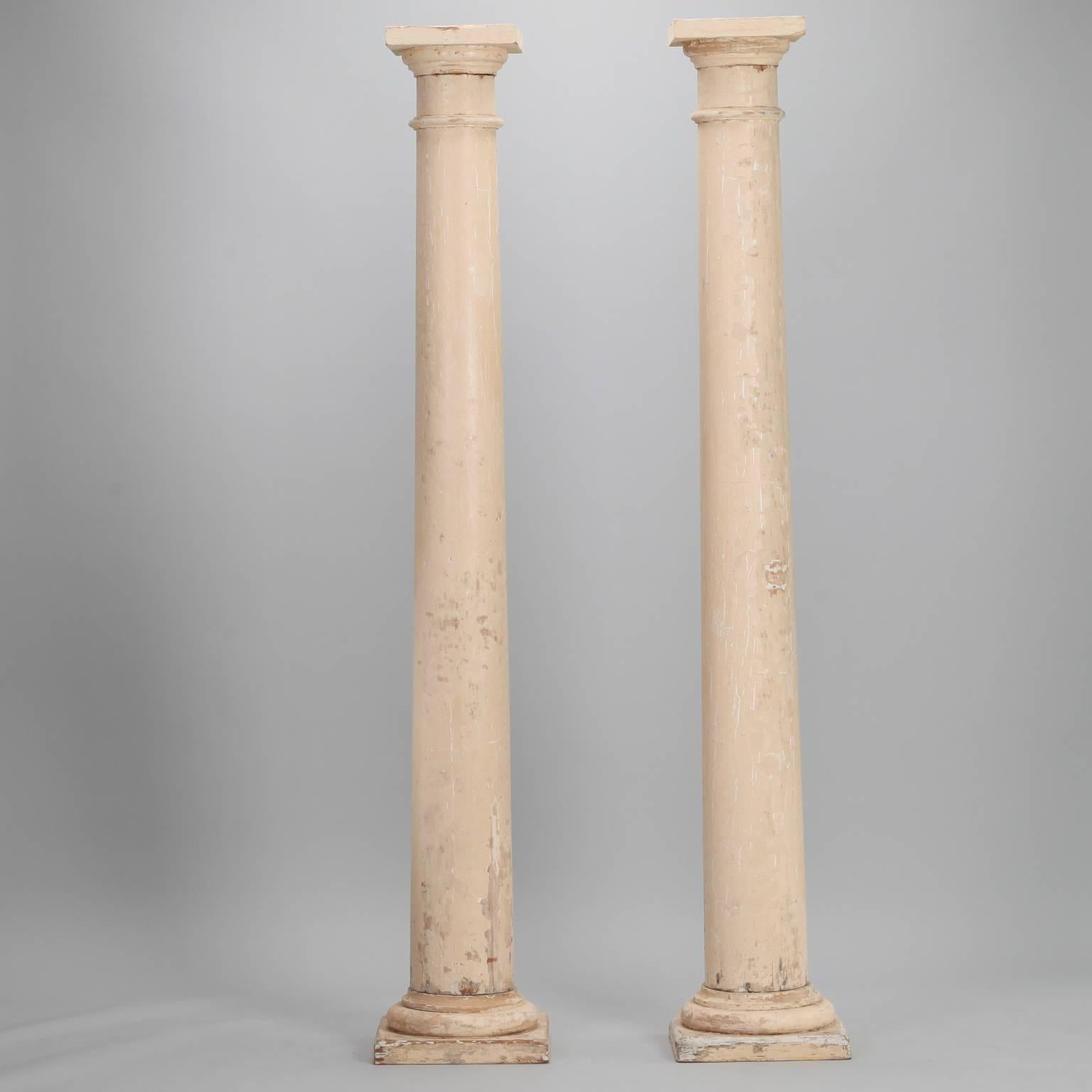 Pair of salvaged wood columns with antique white painted finish, circa 1900. Found in Belgium. Sold and priced as a pair. Excellent structural condition; painted finish has scattered areas of loss and wear.