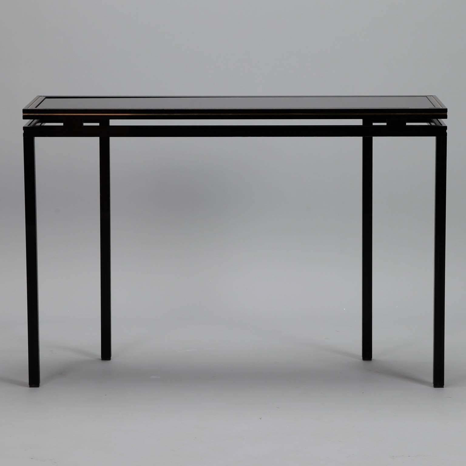 Lacquered wood and glass console by Paris maker Pierre Vandel features sleek, architectural lines and a black finish accented with gold, circa 1970s. Other pieces from this series or style available at the time of posting. Please inquire.