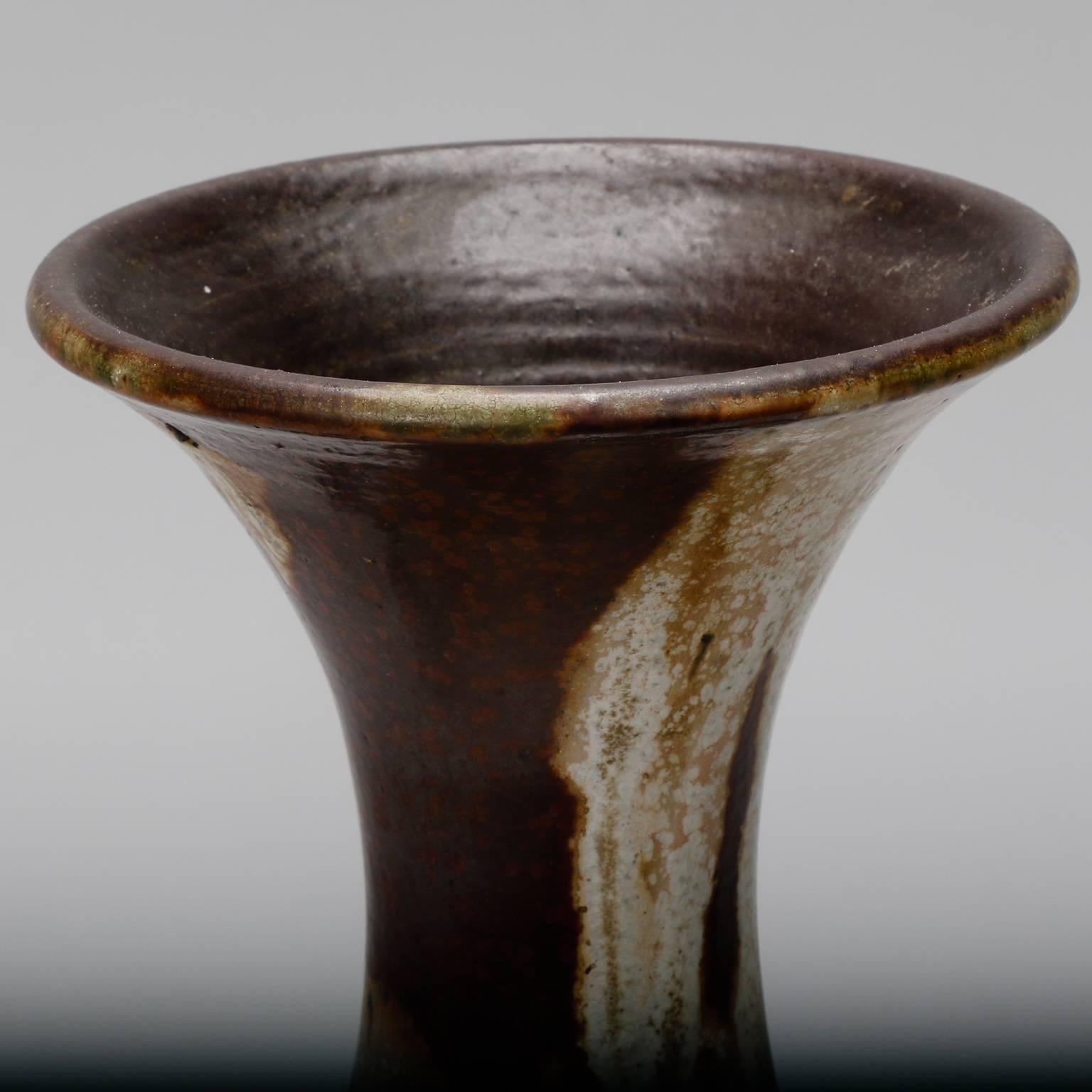 Ceramic vase signed by Belgian artist Maurice Pitot has a drip glaze in earth tones with slender neck and applied, sculpted leaves.
