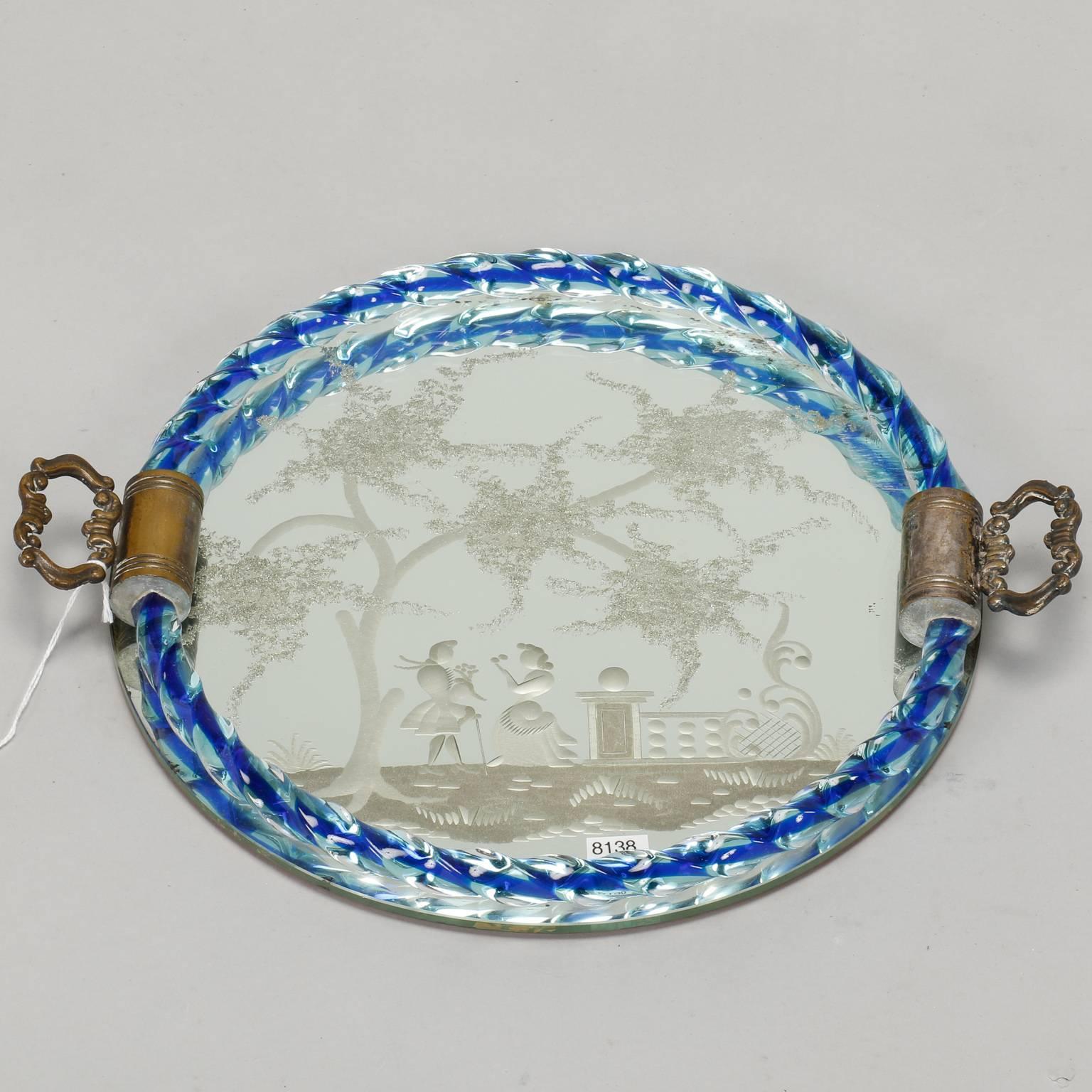 Round Venetian mirrored dresser tray with cast brass handles, blue twisted glass rim and an etched Provincial scene, circa 1940s. Excellent vintage condition.
  
