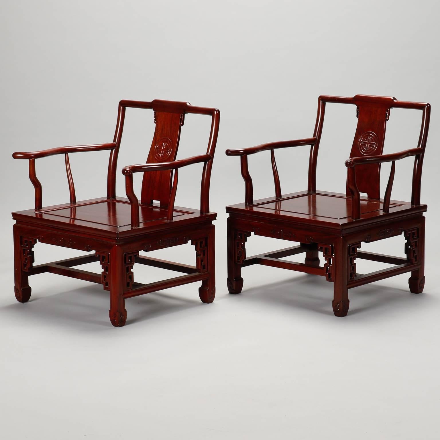 Pair of carved wood armchairs from China. Deep red stained wood with carved details on the feet and backrests. Original satin brocade cushions available for pattern, but interior filling has disintegrated. Seats with no cushions are 14.5