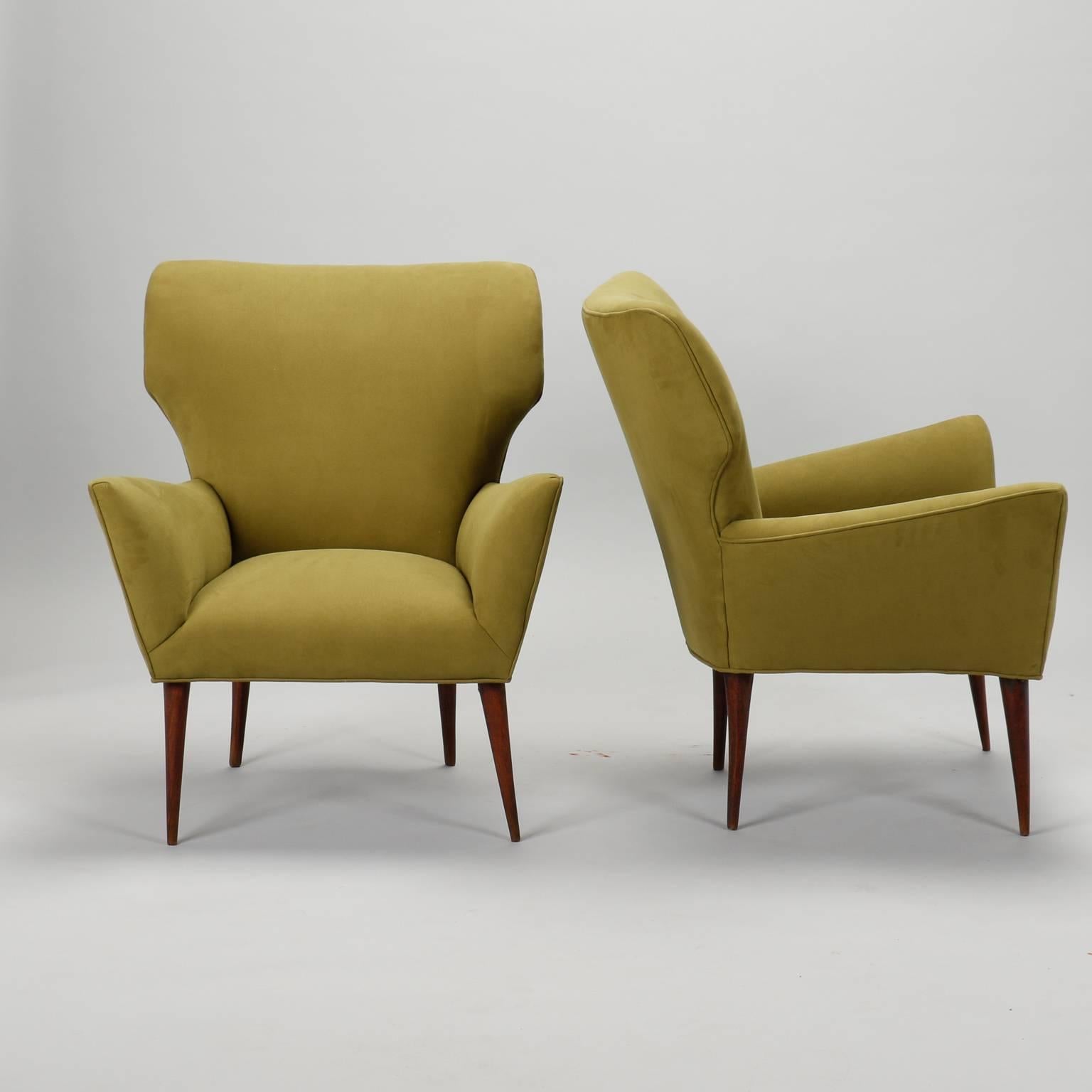 Circa late 1950s-early 1960s pair of Italian armchairs has been newly upholstered in olive green micro suede. Tapered wood legs, curvy Mid-Century Italian styling. Measures: Seats are 15.75” high and 17.5” deep. Arms are 22” high. Sold and priced as