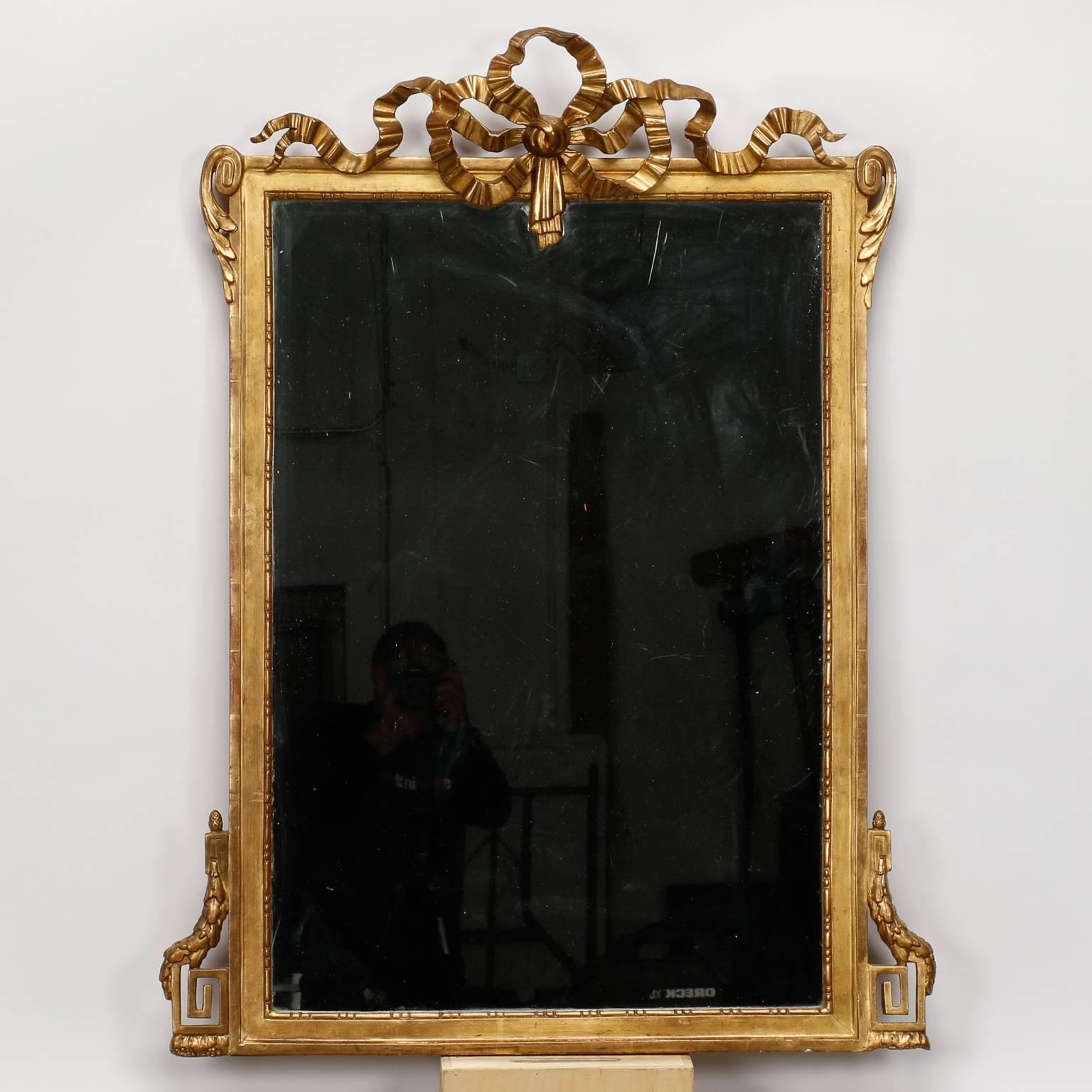 French Louis Philippe mirror with giltwood frame features large, ribbon style crown and Greek key details at the sides, circa 1860s.
  