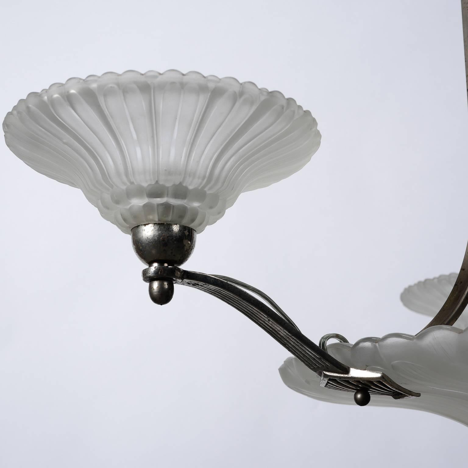 Art Deco chandelier found in Brussels and probably is French in origin, circa 1930s. Center globe is molded satin glass with silver tone metal arms that support three smaller globes. All have been rewired to comply with US electrical standards. All
