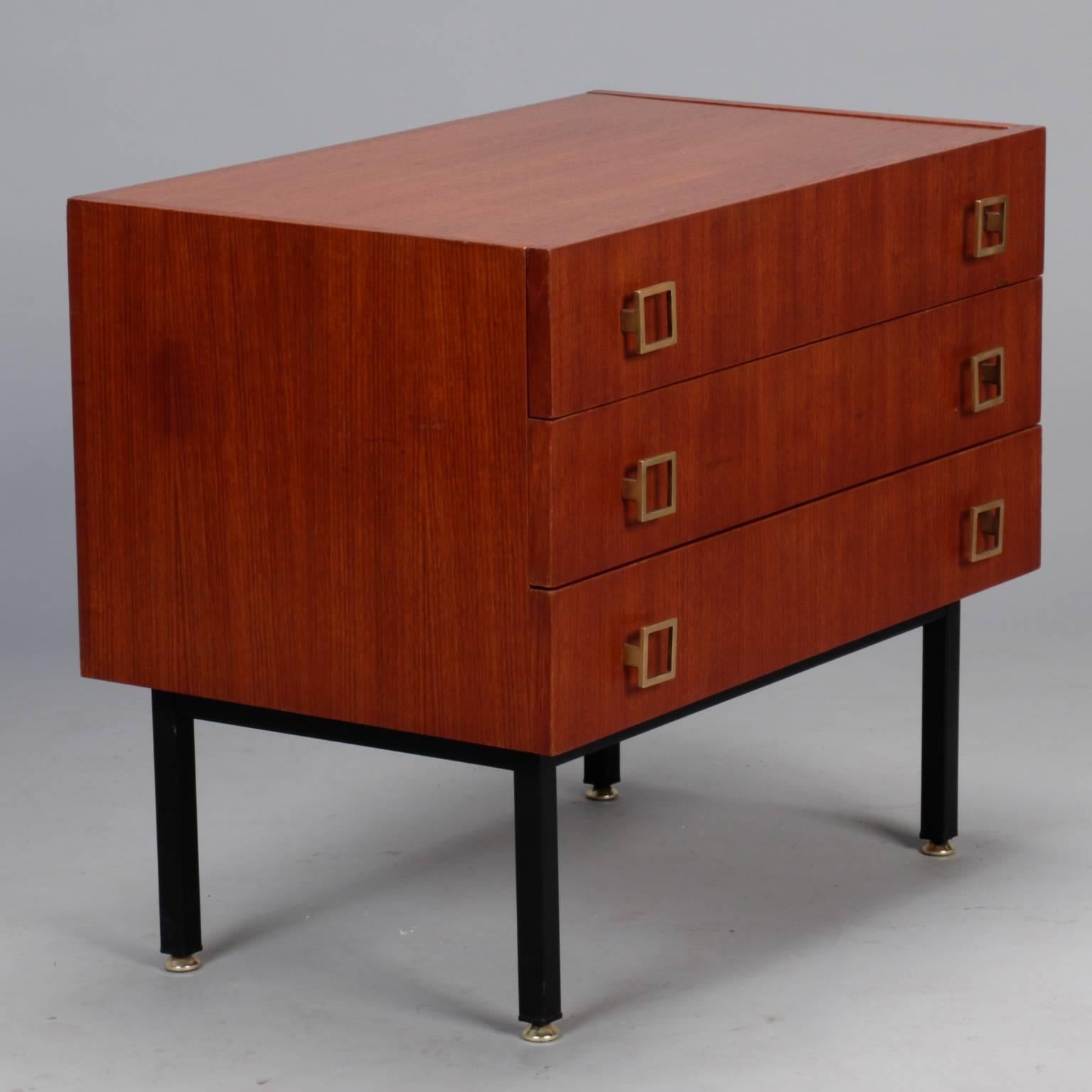 Small French chest of three drawers in mahogany with a streamlined ebonised base and brass feet, circa 1960s. Drawers have dovetail construction and open square-shaped brass pulls.
   