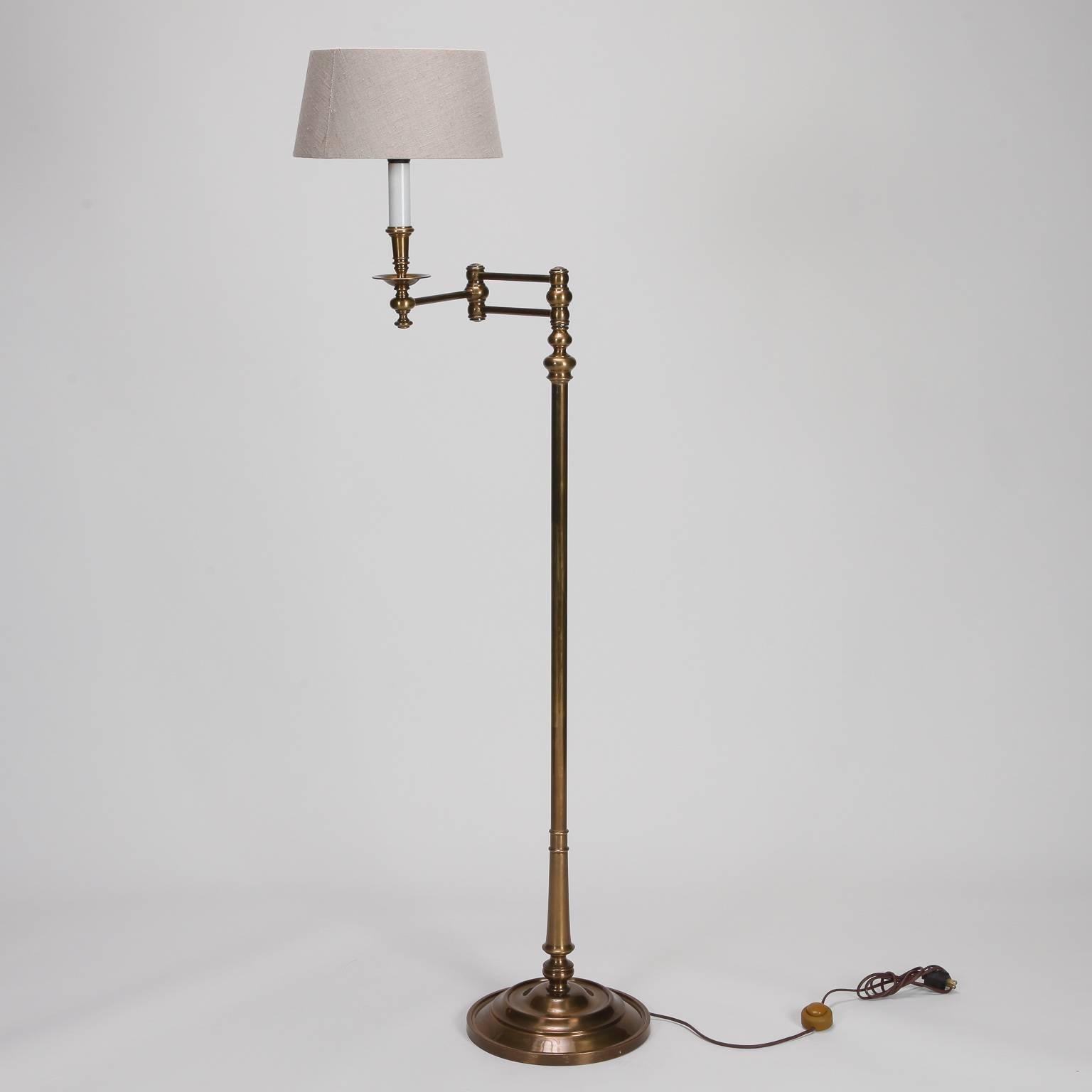 English floor lamp is made of brass, circa 1930s. Swiveling arm makes this perfect for use as a library or reading lamp. Shade shown is included. New wiring for US electrical standards.