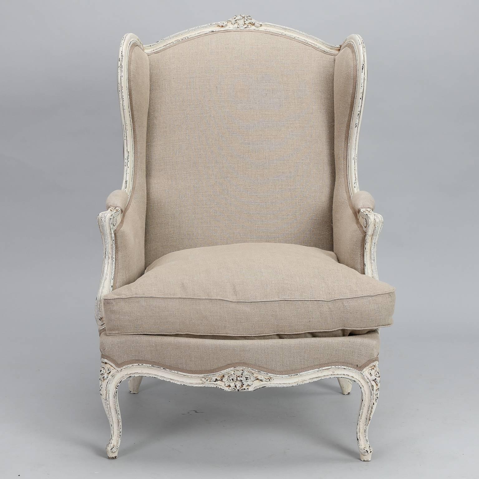 Late 19th century pair of bergere date from 1880s. Antique white painted and carved frames with decorative elements on bottom stretcher, knees and crest. New upholstery in pale beige linen blend fabric, down filled seat cushions. Sold and priced as