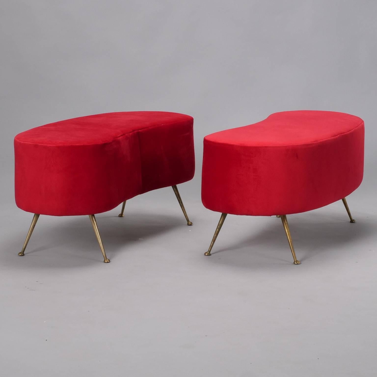 Italian made upholstered bench in manner of Gio Ponti has a kidney shaped body and narrow, tapered brass legs, circa early 1960s. Covered in a true red fabric that has a suede-like appearance and feel. 
     