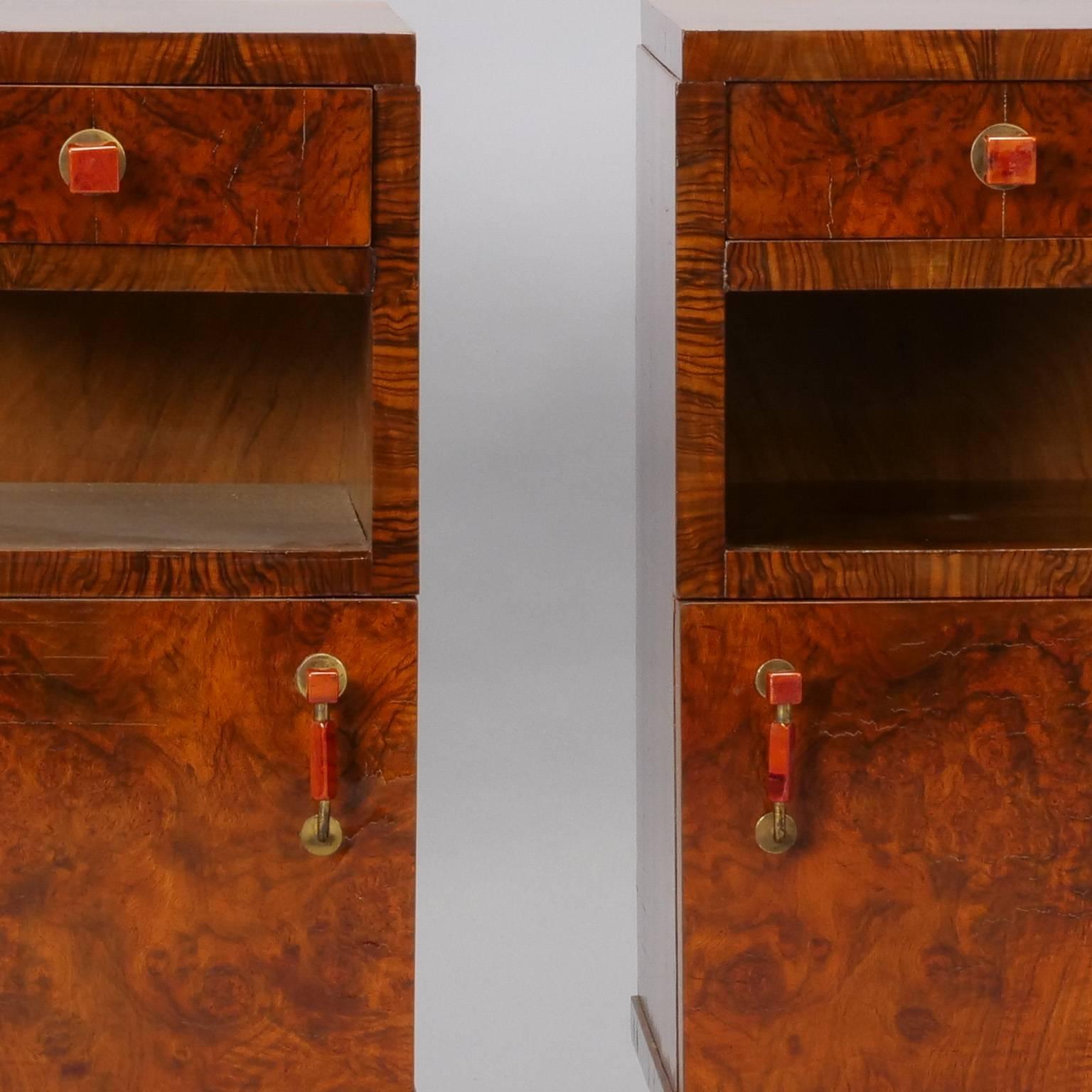 Found in Italy, this pair of Deco era bedside cabinets date from the 1930s and have a dramatic burl wood veneer with one small drawer suspended over an open shelf and lower cabinet with hinged door. Original bakelite hardware. Sold and priced as a