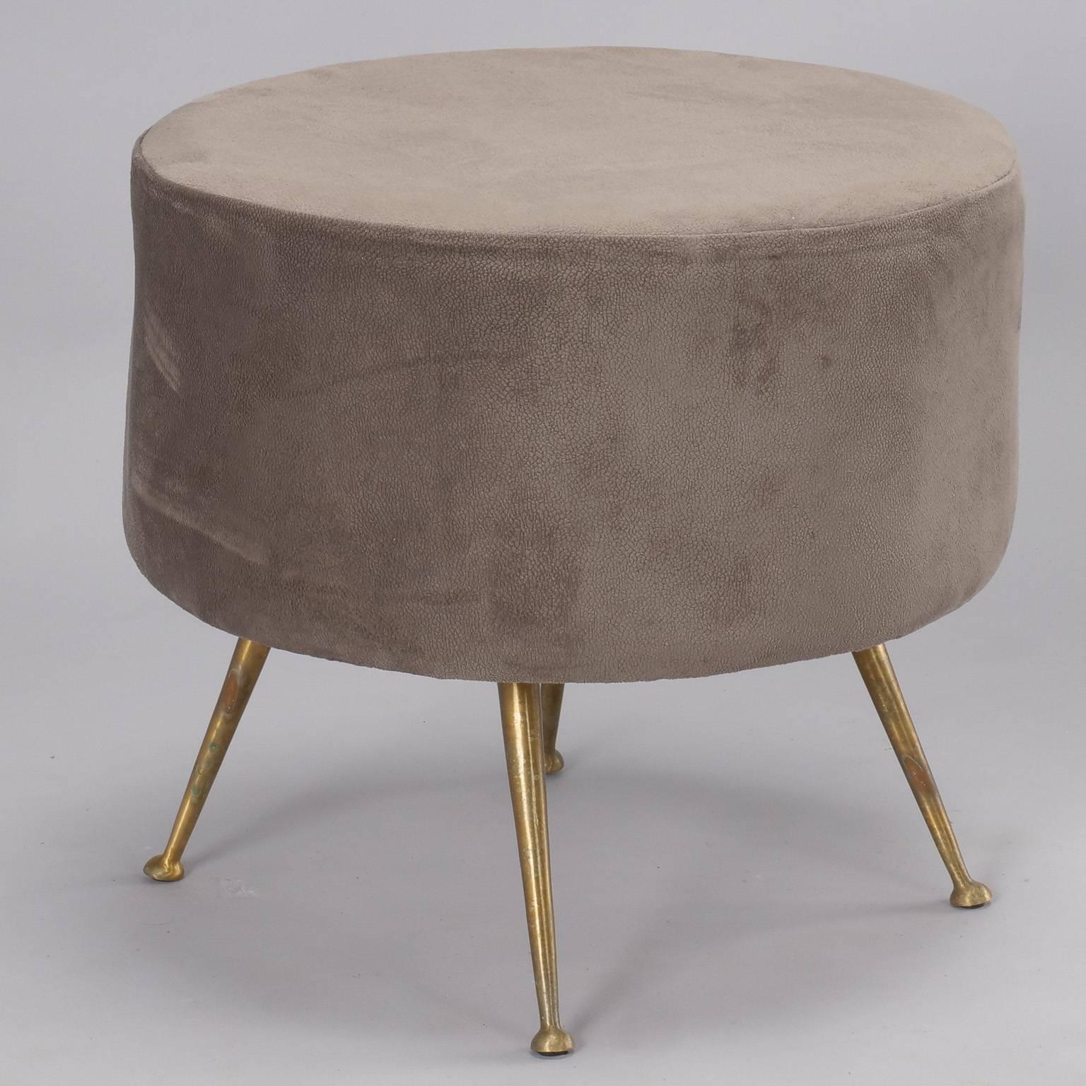 Mid-Century Italian round upholstered stool in style of Gio Ponti upholstered in a light taupe colored moleskin fabric with slim, tapered brass legs. Two stools available at time of posting, sold and priced individually.
 