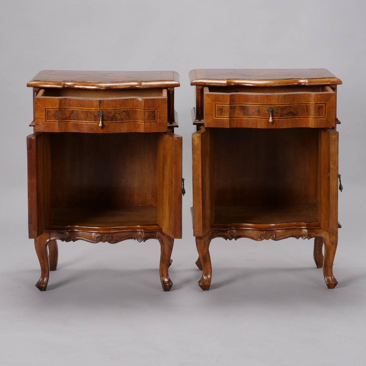 Pair of Italian side cabinets with cabriole legs, single top drawer and lower cabinet with hinged doors, circa 1920s. Beautifully figured walnut veneer, decorative inlay on door and drawer fronts and carved details on edges and apron. Sold and