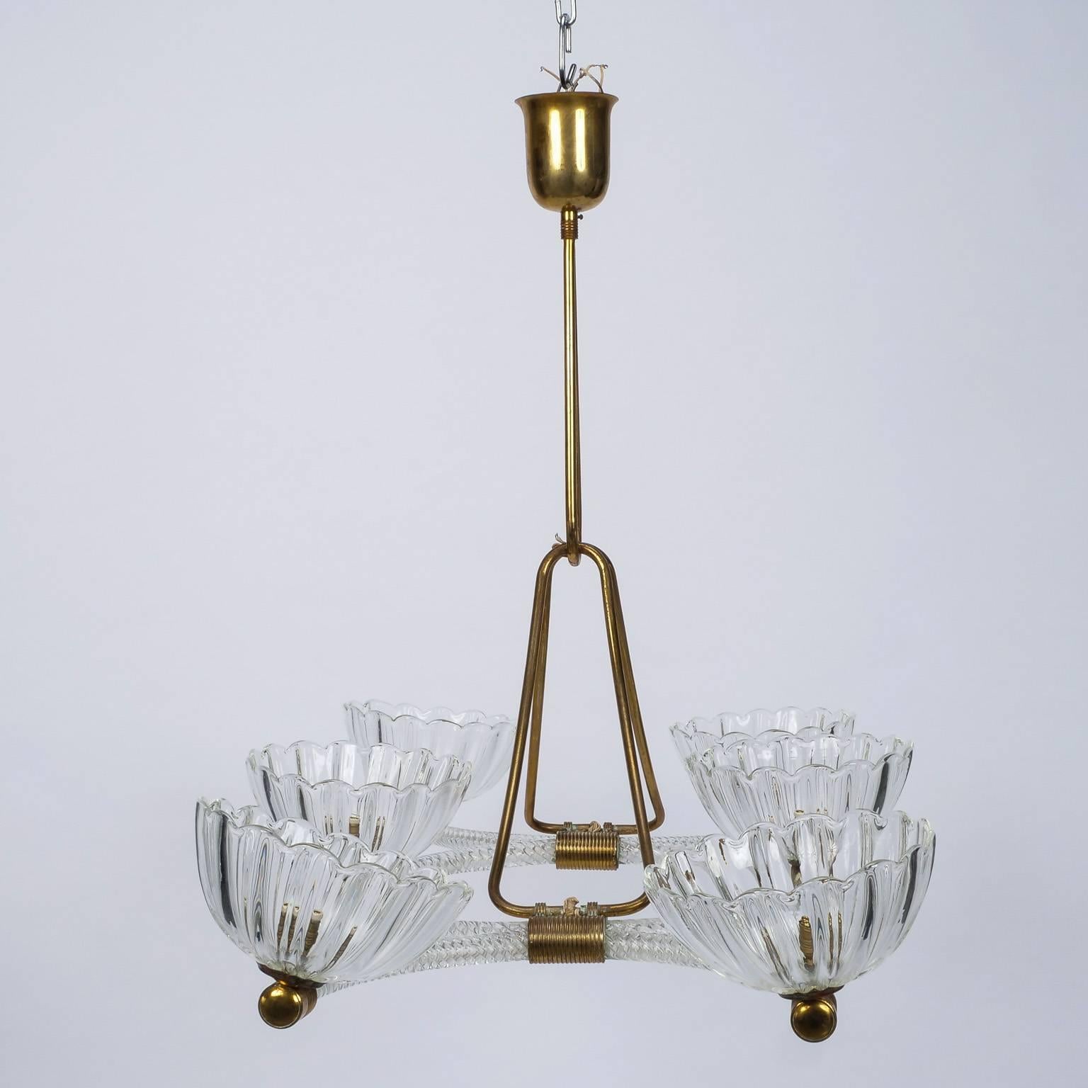 Extra large clear Murano glass six light chandelier attributed to Ercole Barovier, circa 1940s. Chandelier has center ring of ridged glass flanked by an open half circle of glass on each side. Brass suspension and joining hardware, scalloped edge