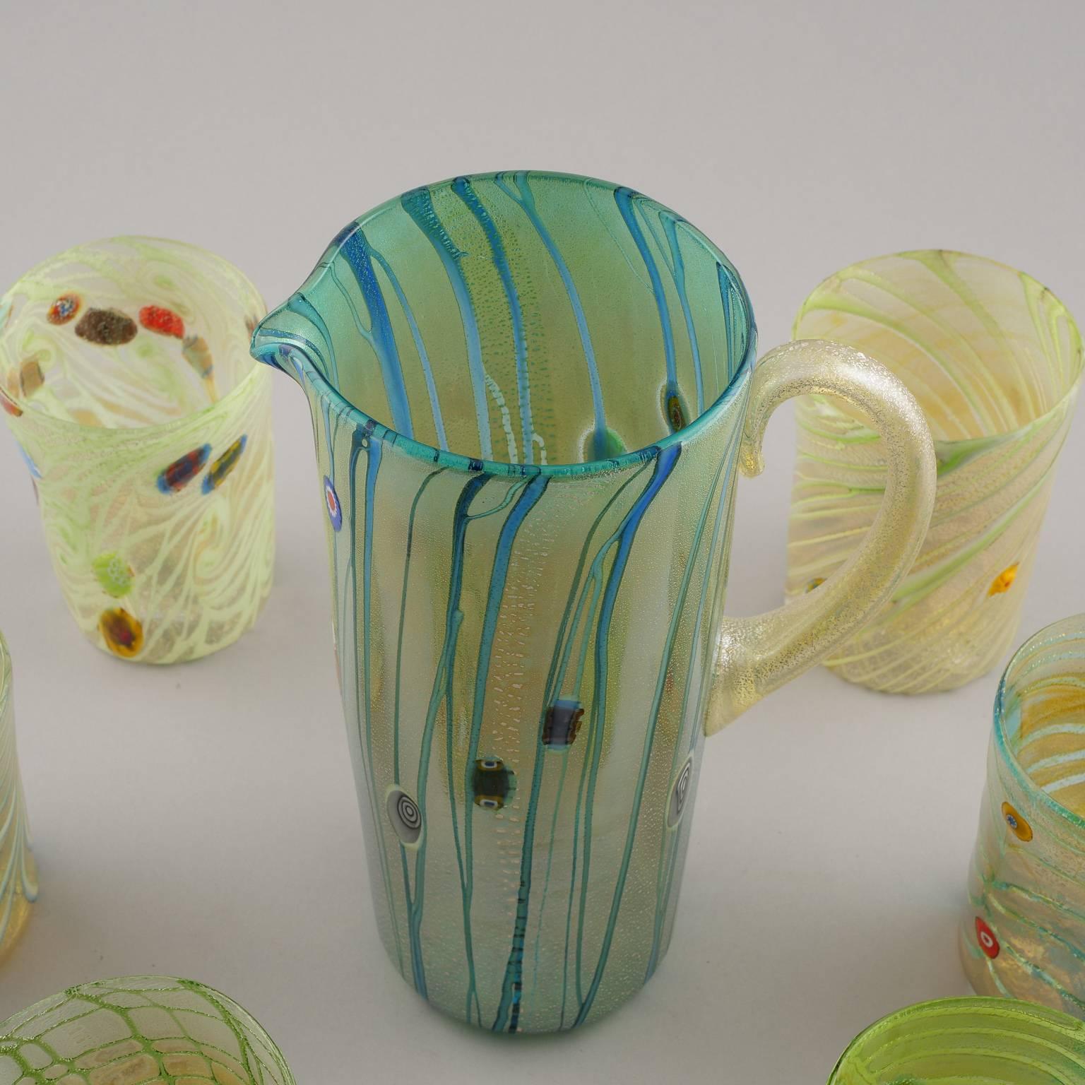 Set of contemporary Murano glass pitcher with six coordinating tumblers. Colors of set are green, yellow with streaks of blue and some ruby red floral accents and iridescent sheen. Makes a great gift!