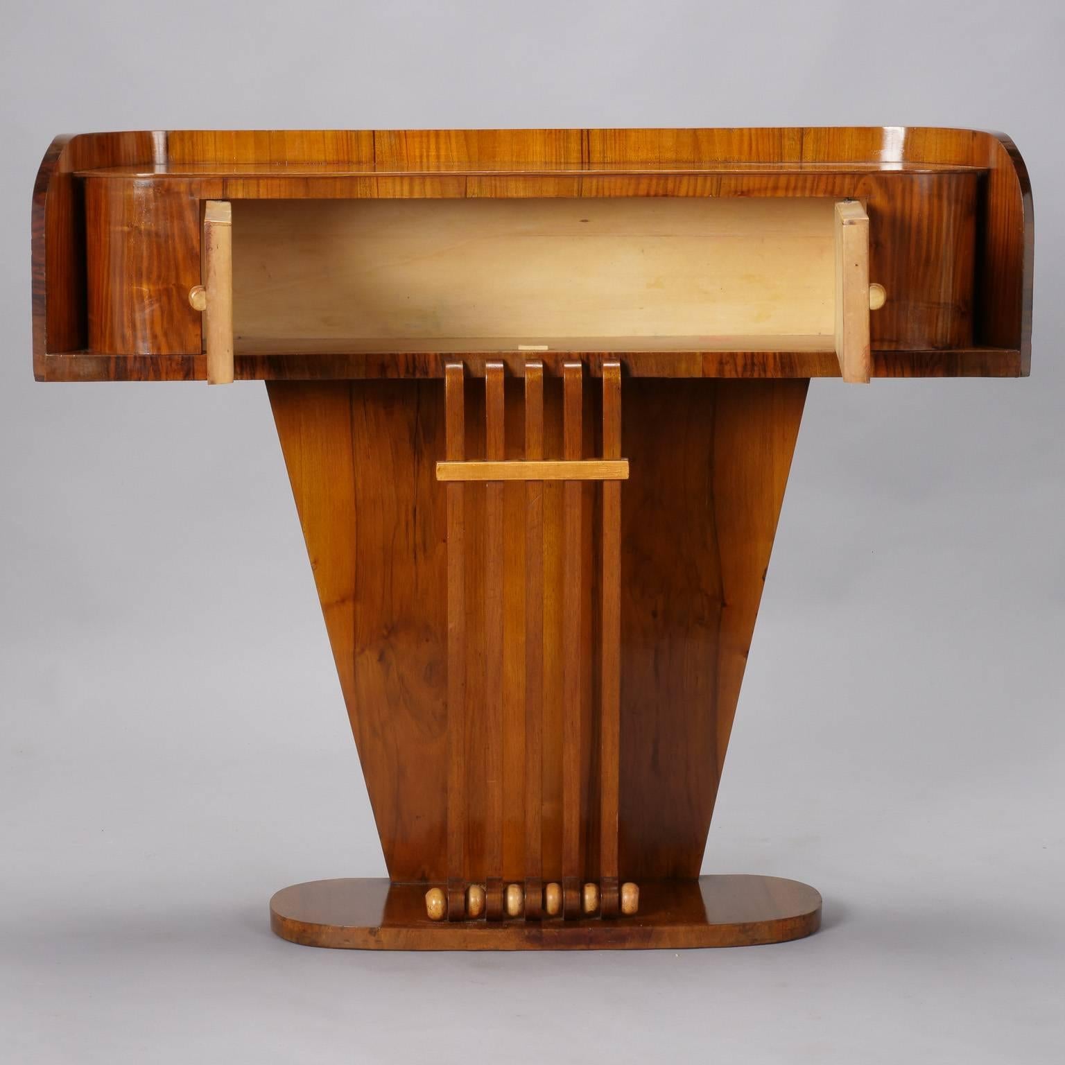 Italian Art Deco console with contrasting wood, circa 1930s. Polished burl wood with two hinged contrasting blond wood door cabinets and pedestal base. Unknown maker.