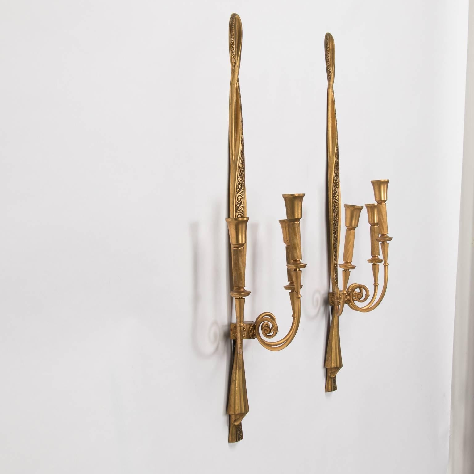 Gilded metal neoclassical style sconces by Lumi feature three candelabra size sockets each and are over 30” tall. Sconces are sold individually. Manufacturer's mark on back. New wiring for US electrical standards, circa 1940s.
      