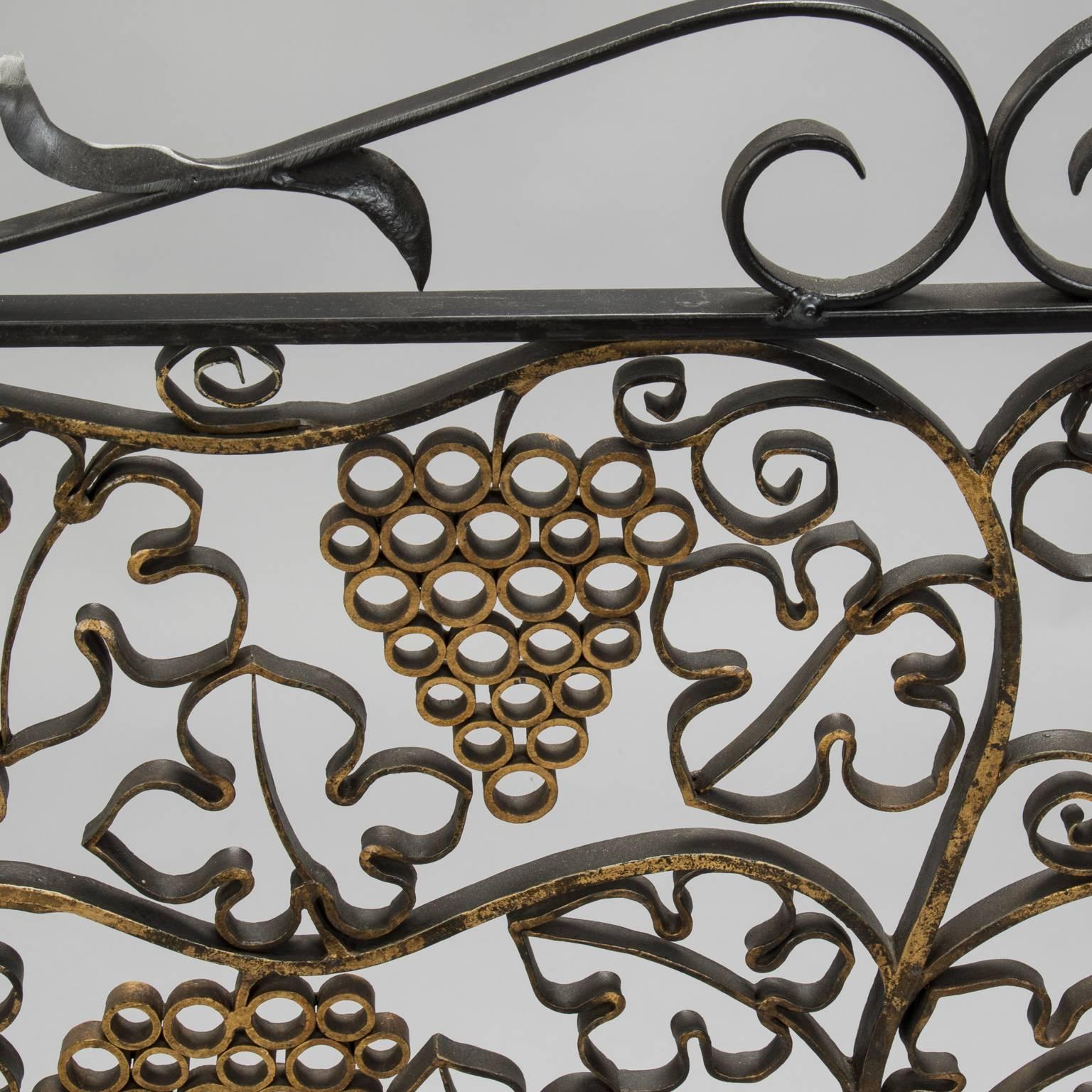 Custom fireplace screen made from circa 1930s decorative French iron grill featuring an urn with grape vines and fruit. Stand alone screen has black iron feet and decorative scroll work at the sides and crest. Beautiful, one-of-a-kind piece.