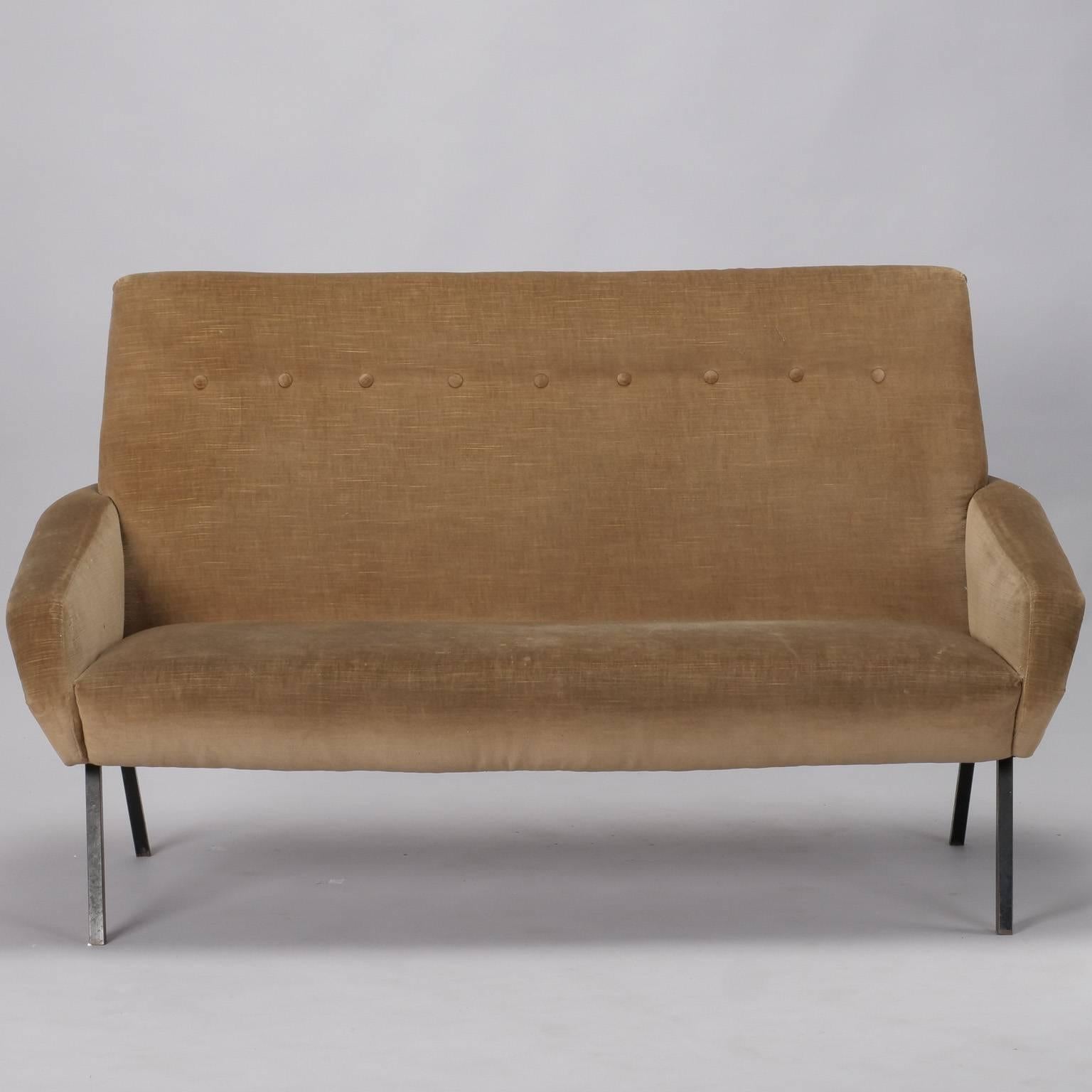 Italian settee in manner of Zanuso has tight seat back with a single row of button tufting, brass nailhead trimmed arms and metal canted legs. Black paint on legs has been touched up since photos. Upholstered in taupe colored chenille/velvet that