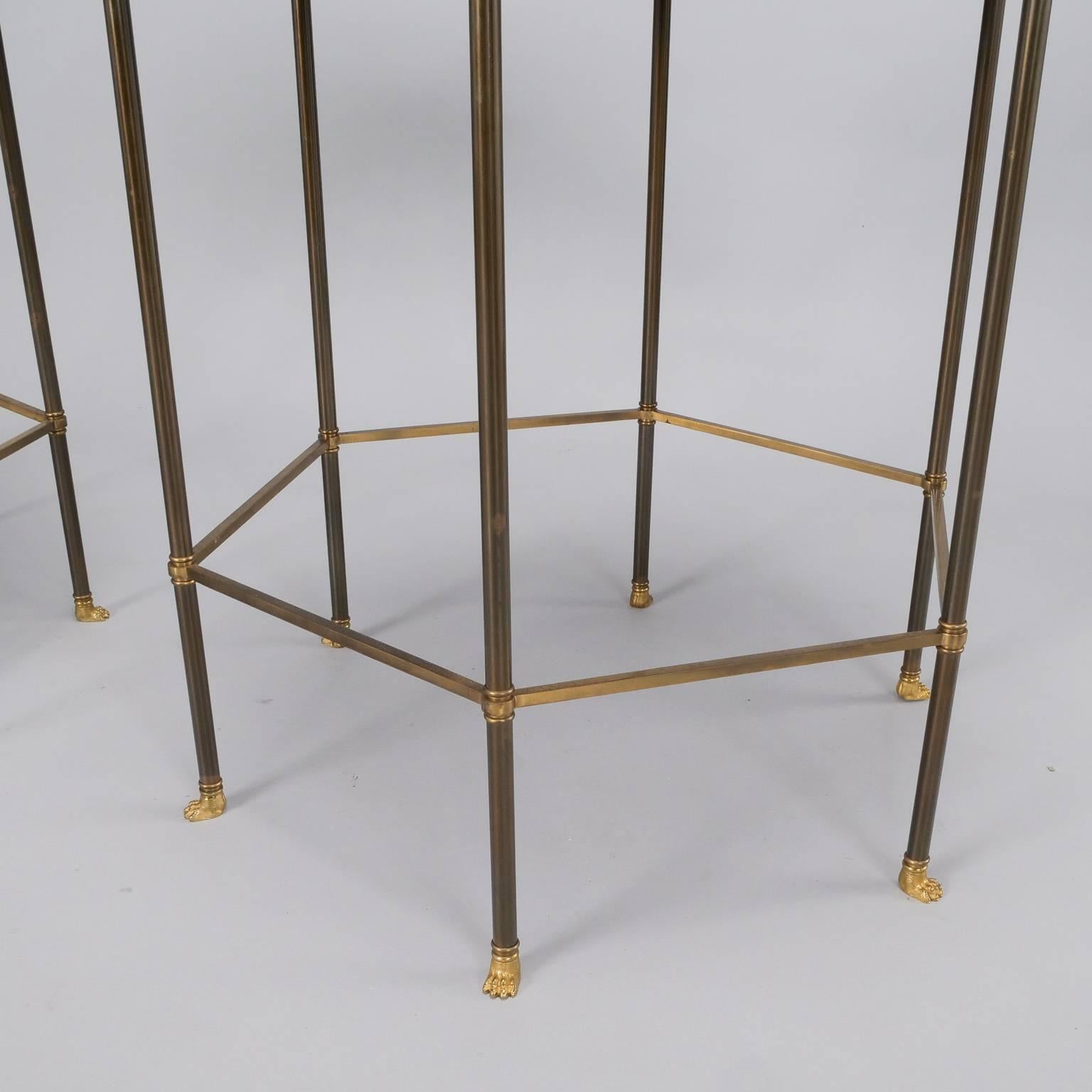 Pair of circa 1960s six-sided brass frame side tables from famed French maker Maison Charles. Each table has six slender brass legs with lion style feet, six sided brass stretcher, delicate brass gallery and tortoise look enameled table tops. Sold