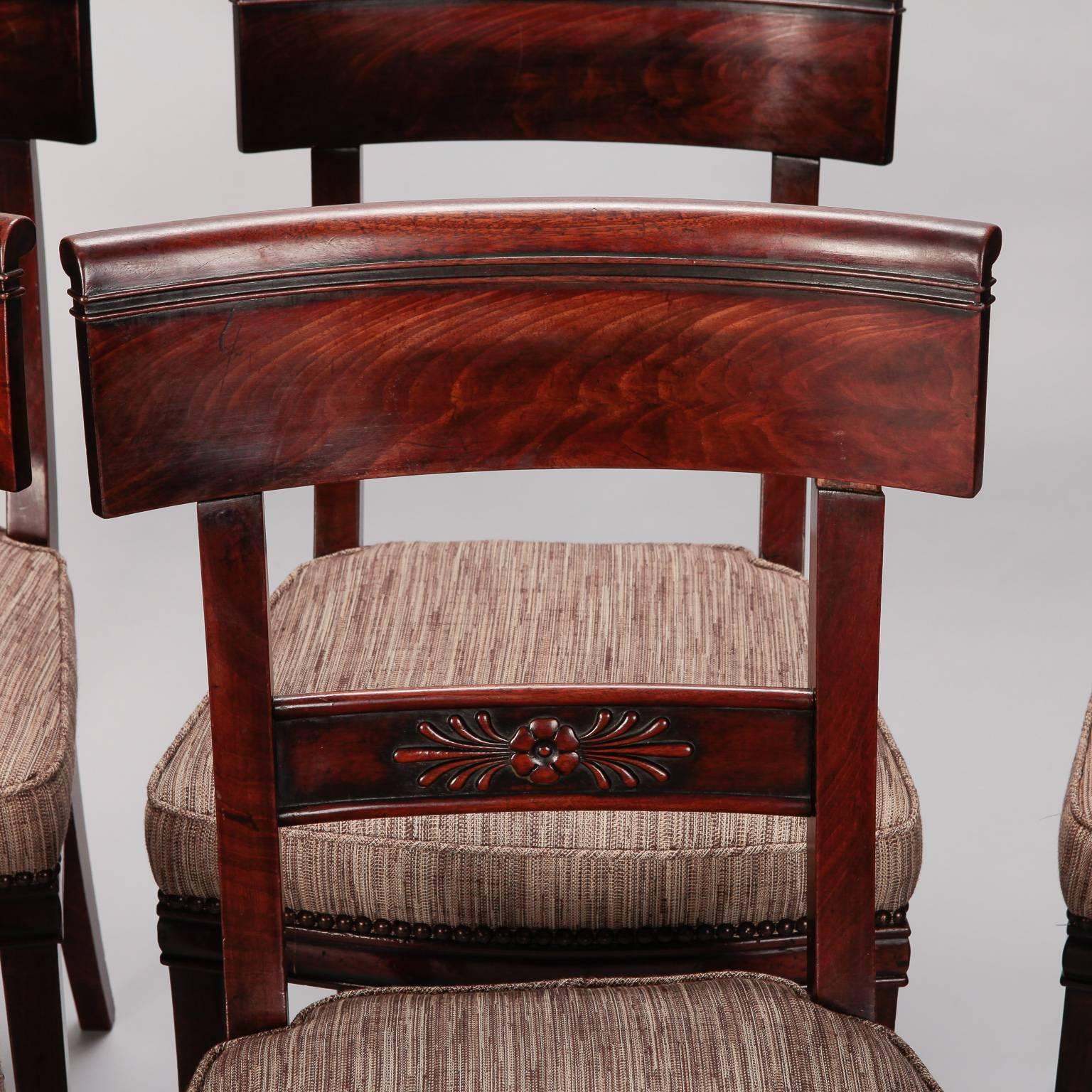 Set of six French dining chairs with newly upholstered seats and carved walnut frames, circa 1825. Newly upholstered in brown tone tweedy woven fabric with brass nail head trim. Carved floral medallion detail on seat back slats. Measure: Seats are