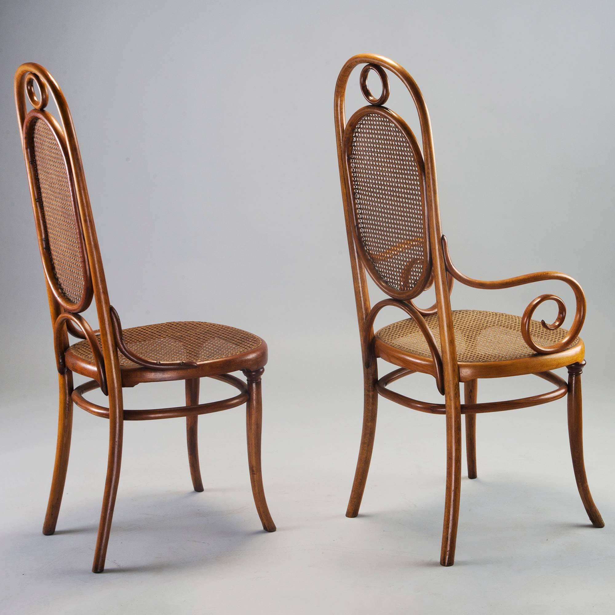 Set of eight bentwood Thonet model 207R chairs also known as Long John - with two armchairs and six side chairs, circa 1910. Made in Vienna, these chairs have beechwood bentwood frames with caned seats and back rests. Arms are 27