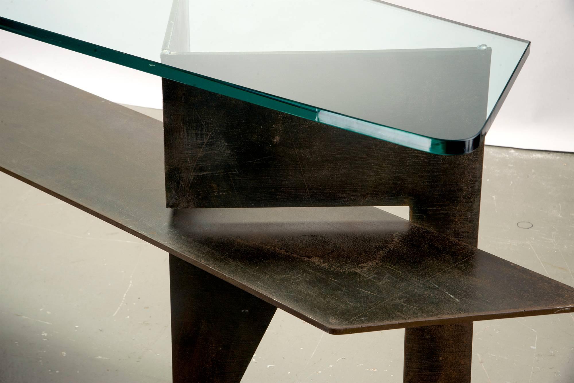 Found in Italy, this Brutalist style console has an iron base and thick glass top with polished edges, circa 1970s. Tabletop and lower iron shelf can be flipped or be oriented the other way if preferred. Unknown maker.