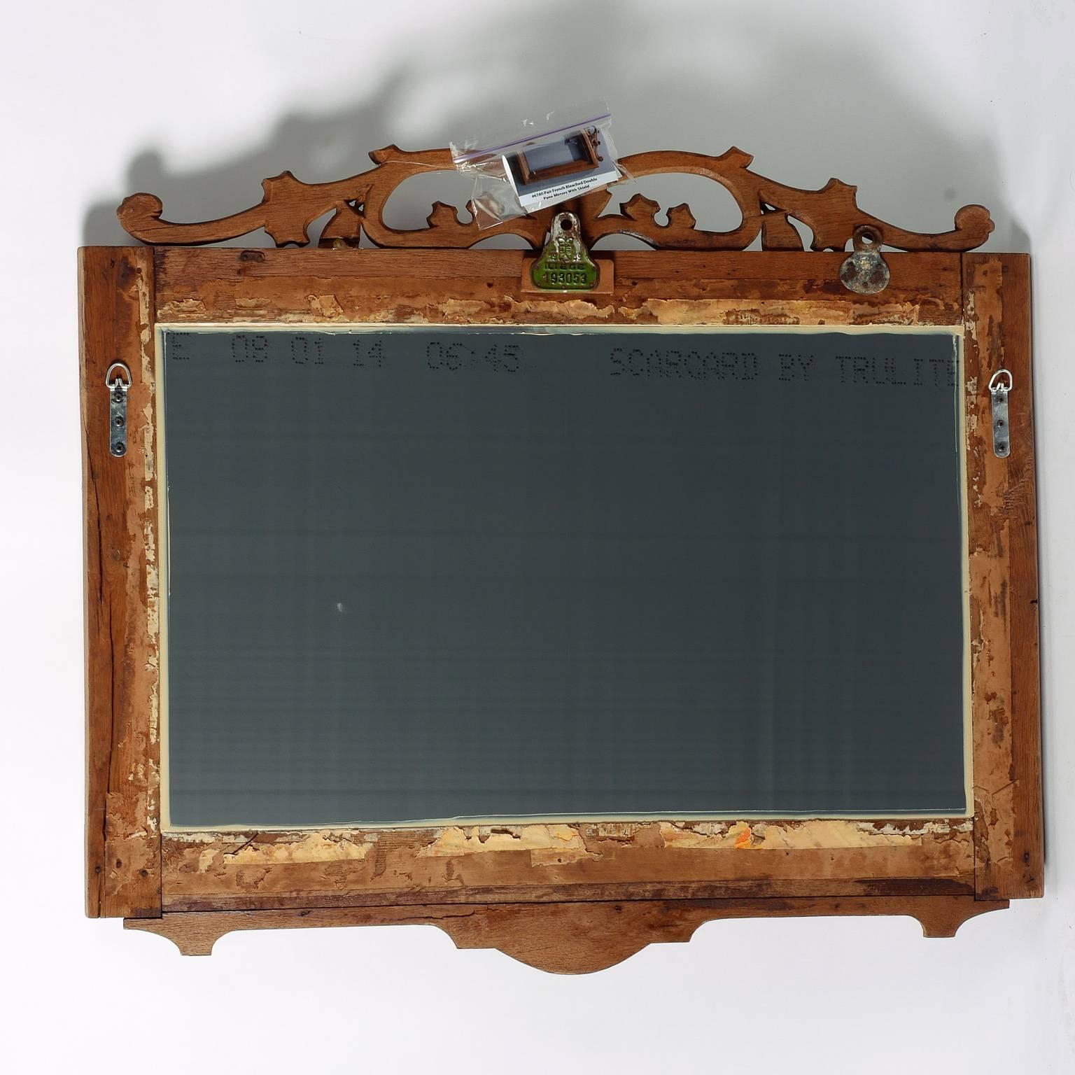 French pair of mirrors have bleached wood double pane frame with carved, open work detail including shield at the crest, circa 1900. Sold and priced as a pair.