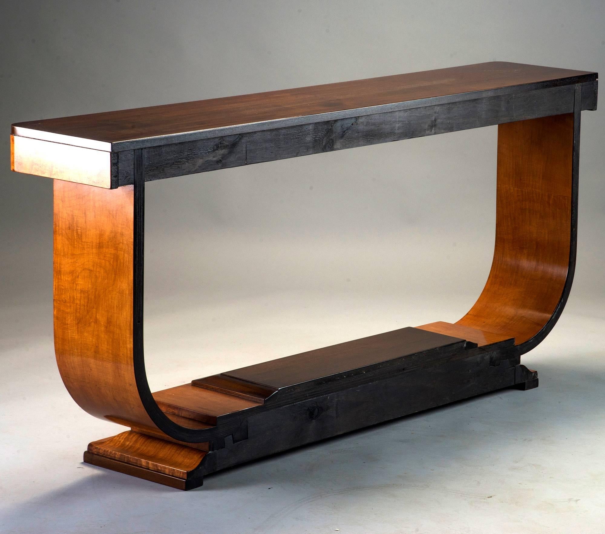 Art Deco console has contrasting lighter and darker wood - believed to be maple or birch and walnut, circa 1930s. Pedestal base in light wood with stepped dark wood detail, curved side supports, light apron and contrasting dark tabletop. Original