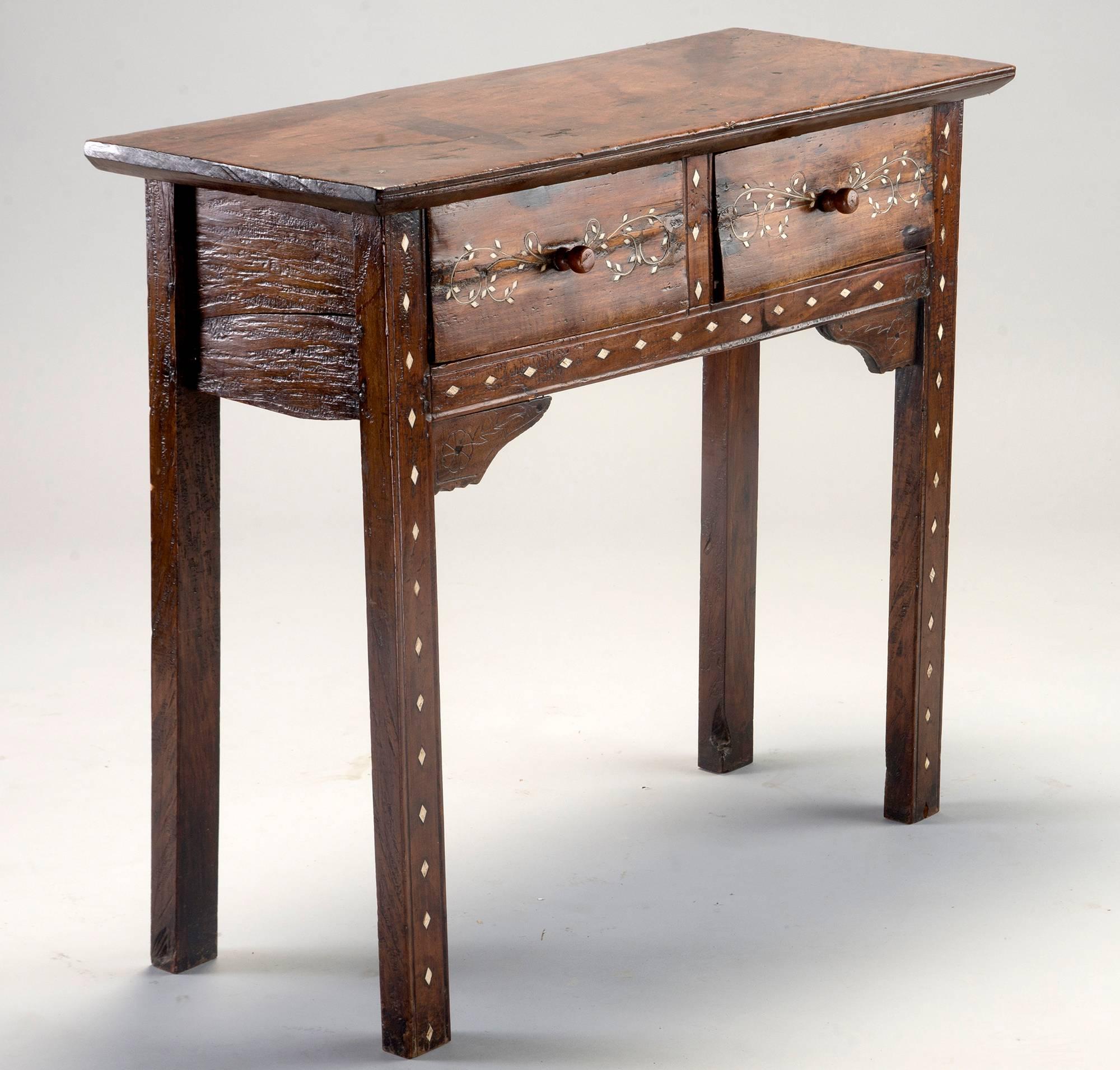 Small dark wood console has two drawers, and bone inlay in a diamond pattern on front legs and apron and a leaf and vine inlay pattern on drawer fronts, circa 1920s. Moorish style - but also could have been crafted in India or the Middle East.