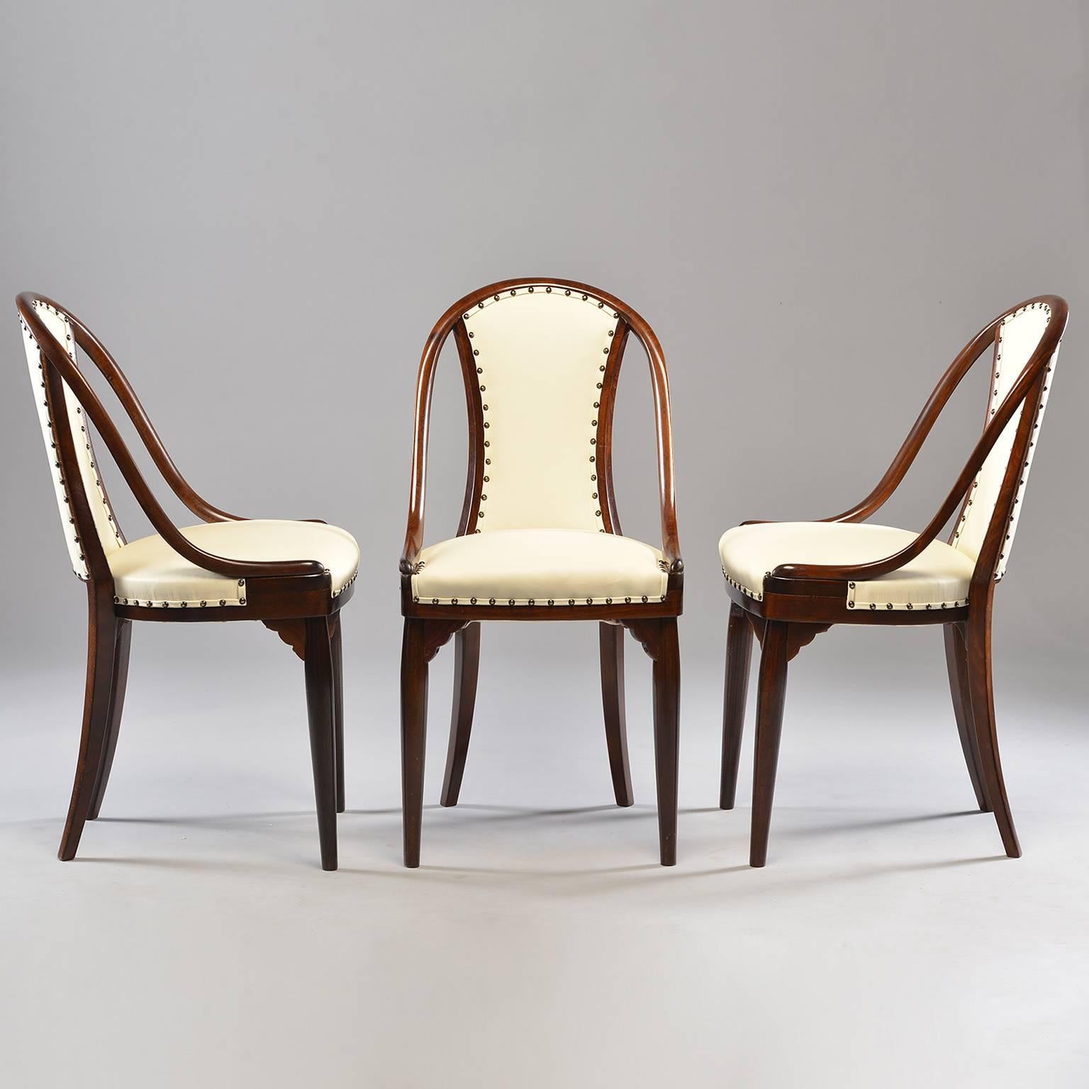 Set of six chairs attributed to Otto Prutscher for Thonet of Austria, circa 1920s. Dark bentwood frames with padded seats and back rests. Decorative fluted front corner leg supports. New off-white leather upholstery embellished with dark brass