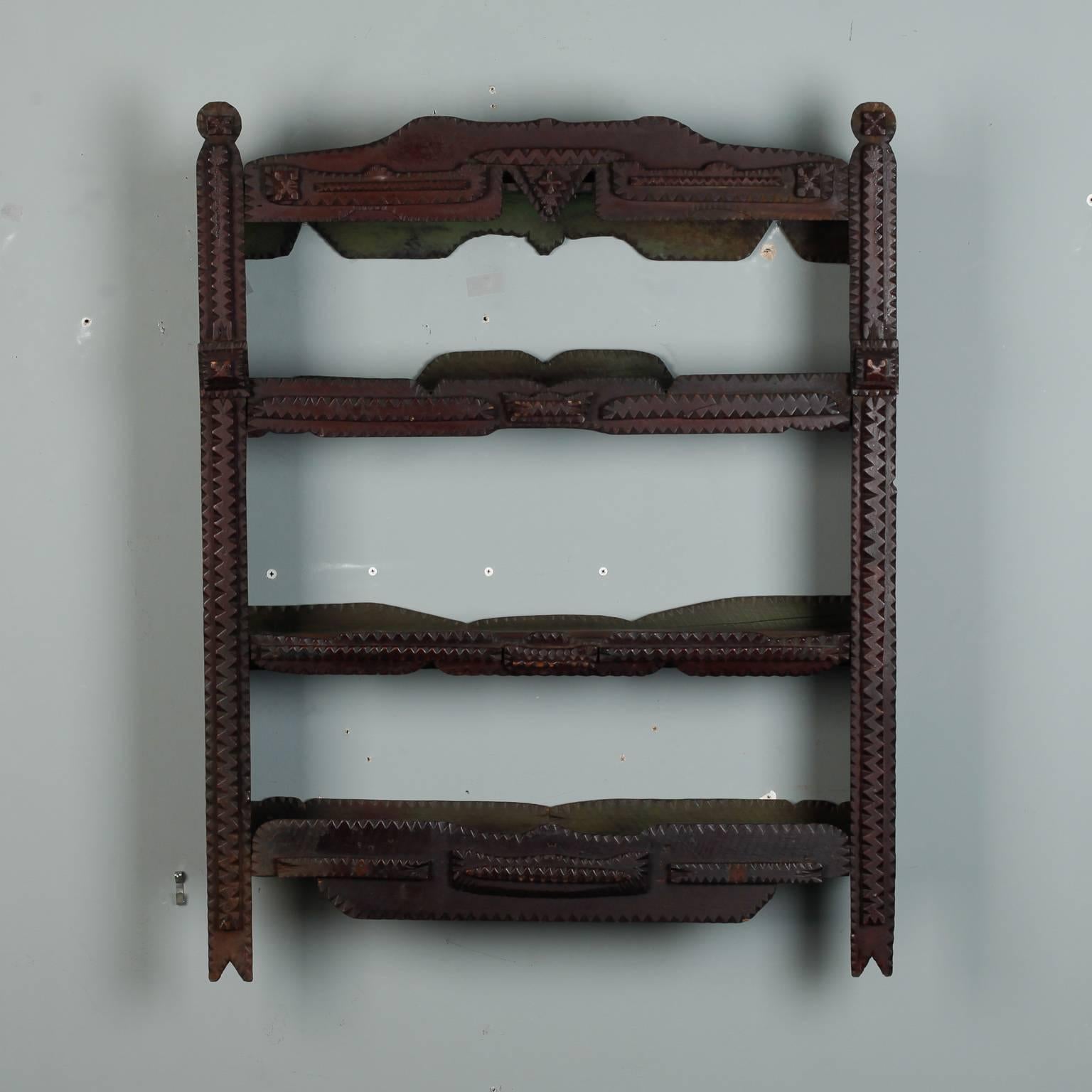 Wall mounted shelf unit dates from late 19th century - approximately 1880. Hand carved dark stained wood features classic tramp art design with saw tooth, notched edges. Found in Europe. 

Dimensions: 44” H x 35” W x 7” D

Retail: $2,495.00