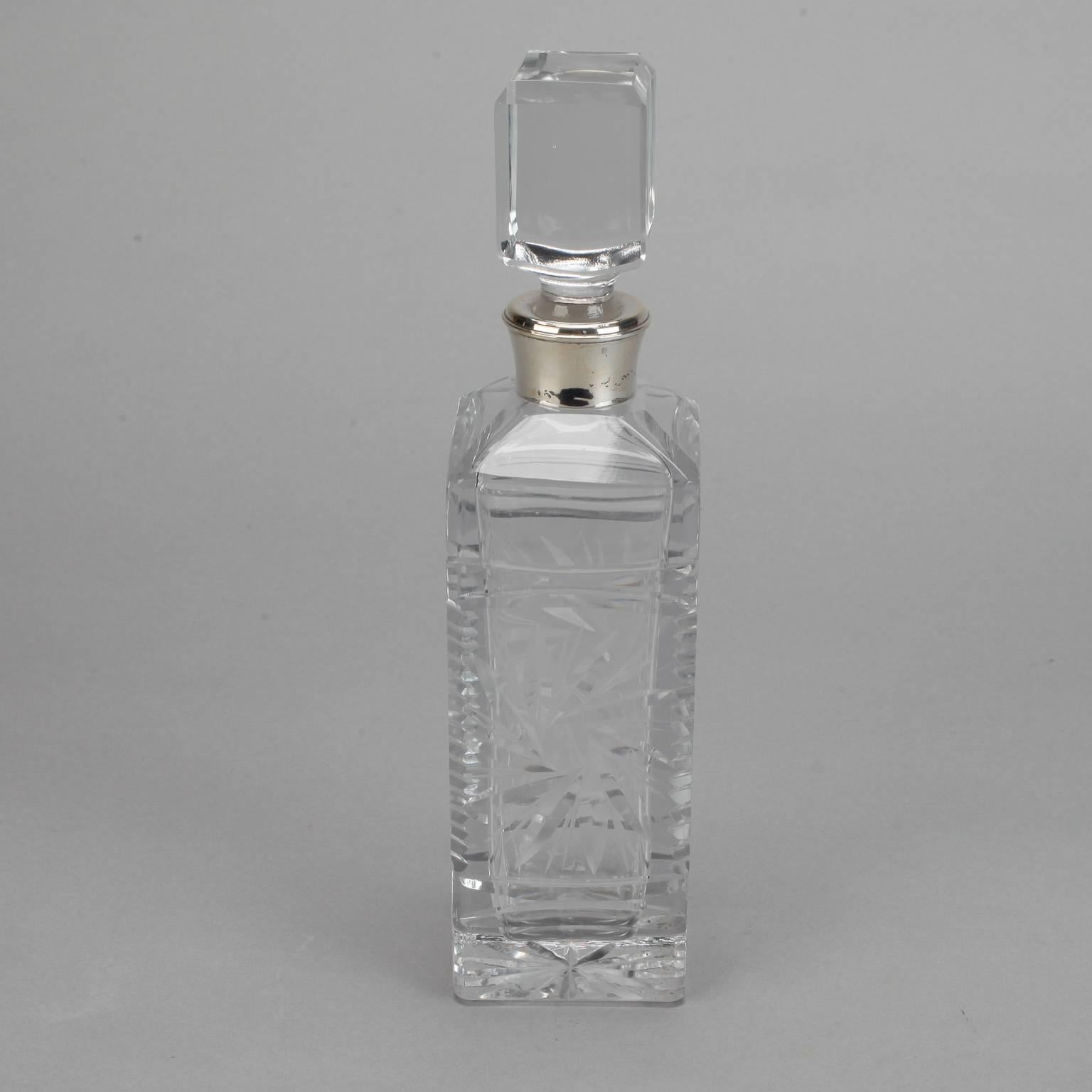 Heavy cut crystal decanter found in Belgium, circa 1930s. Rectangular vessel has ornamental starburst pattern on panels, sterling silver band around neck and large square crystal stopper.