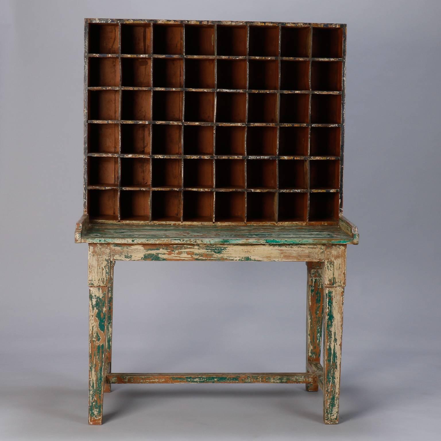 Circa 1900 postal sorting desk with attached mail compartments.  There are 48 mail cubbies that each measure 5” H X 5” W X 6.75” D.  Markings on the compartments include many of the original names / numbers. Original green and ivory paint has been